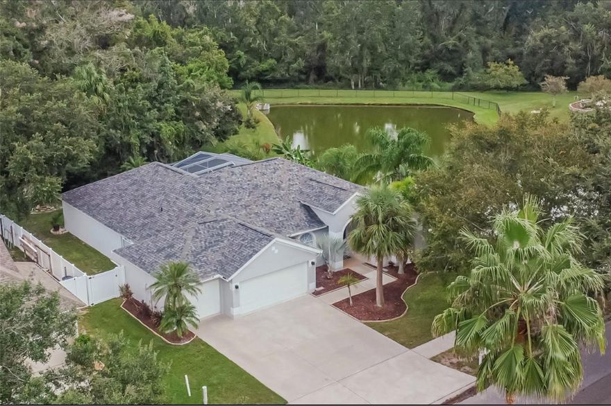 OVERLOOKING A TREE-LINED POND instead of a back neighbor, the private pool lanai behind this beautifully updated property is screened and roof-sheltered for all-weather enjoyment! It’s also just 1 highlight of the 2,270-SF home with new porcelain tile floors, new stainless-steel appliances, renovated bathrooms, granite counters, wood cabinets, and a distinctively shingled roof just 4 years old. Fruit trees and fresh landscaping adorn the yard that actually spans nearly an acre of conservation land even though you pay taxes on only the front 20%. That's typical for a place like this in Riverwatch, the security-gated section of Riverglen, but it's hard to beat among the competition! This Windward St. Croix design welcomes you through double doors to formal living and dining rooms in front, a casual family room and kitchen in back, with both areas opening through sliders to the pool lanai for expansive entertaining. The 4 bedrooms and 2 full baths are arranged with an owner suite in the right rear corner featuring dual closets, dual sinks, and its own set of sliders to the lanai; another bedroom and hallway bath that access the pool through sliders and a door; then the other bedrooms with walk-in closets in the opposite rear corner. All bedrooms feature ceiling fans and flat-screen TVs. Other quality upgrades include 2 walk-in showers with porcelain tile and rolling glass doors, a designer soaking tub in the owner's bath, and a big stainless-steel utility sink in the laundry room between the kitchen and 3-car garage. Perhaps best of all, it's in an excellent neighborhood with playground parks and sports courts near fine schools, shops, restaurants, recreation options and transportation routes. You want to live here!