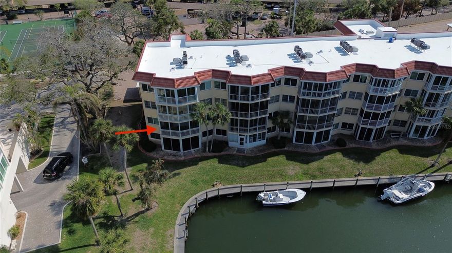This appealing corner residence located on the second level in the Albacore Building inside SIESTA HARBOR offers the convenience of a walk-up or elevator access.  This home boasts a large covered balcony showcasing stunning canal views and beautiful landscaping.  Community docks are available on a first come first serve basis; accommodating boats up to 30 ft.   Deep water canal with direct access to the Intracoastal.  Boating is not complicated when you can dock behind your residence!  Natural light pours into the combined dining and living area from the numerous extra windows being a corner unit.  The active clubhouse and vibrant over 55 community add to the appeal of Siesta Harbor.  Residents enjoy a heated pool, outdoor spa, indoor sauna, fitness room, shuffleboard court, renovated clubhouse featuring a full kitchen, and outdoor barbeque area.  Residents also have a dock/fishing pier on site.  Residents also enjoy private beach access directly across the street!  This home features tile and luxury plank flooring throughout and comes turn-key, fully furnished.  Just bring your bathing suit and start enjoying the island lifestyle.  Additionally, you have the option to rent it out on a monthly basis when not in use.  HOA fees cover the building exterior, cable, escrow reserves fund, fidelity bond, flood insurance, ground maintenance, recreational facilities, trash removal and water/sewer.