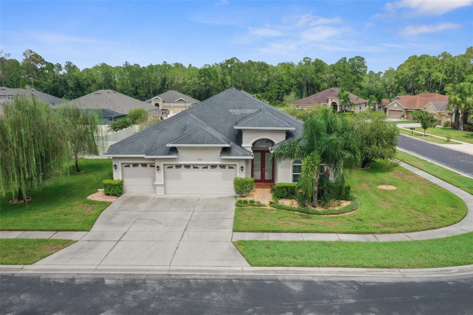 One or more photo(s) has been virtually staged. Welcome to Quail Woods, a gated Wesley Chapel community where elegance meets everyday comfort. This 4 bedroom, 3 bath home with a 3 car garage offers 2,657 sq ft of thoughtfully designed living space. Step through the covered entry into a foyer leading to formal dining and dedicated office space with newer flooring (2017). The heart of the home is a gourmet kitchen featuring rich wood cabinetry (2018), granite countertops, tile backsplash (2018), stainless steel appliances, large island, and an extended breakfast bar, perfect for entertaining. The kitchen opens to a spacious family room with triple sliders that seamlessly connect to the extended covered lanai (2018) for true Florida indoor, outdoor living.
The owner’s suite boasts newer flooring (2017), dual walk-in closets and a spa like bath with soaking tub, oversized walk in shower, dual vanities, and elegant tile finishes. Secondary bedrooms are split for privacy, including one with an pool bath. A generous laundry room with tub and storage adds convenience. Water heater 2025.
Built in 2015, the home is both energy efficient and modern. Set on nearly 1/3 acre, the property balances space and privacy. Low-fee Quail Woods offers nature trails, playground, and BBQ areas, not to mention TV and internet included, all just minutes from top schools, shopping, dining, and I-75.
This move in ready gem is the perfect blend of style, function, and location.