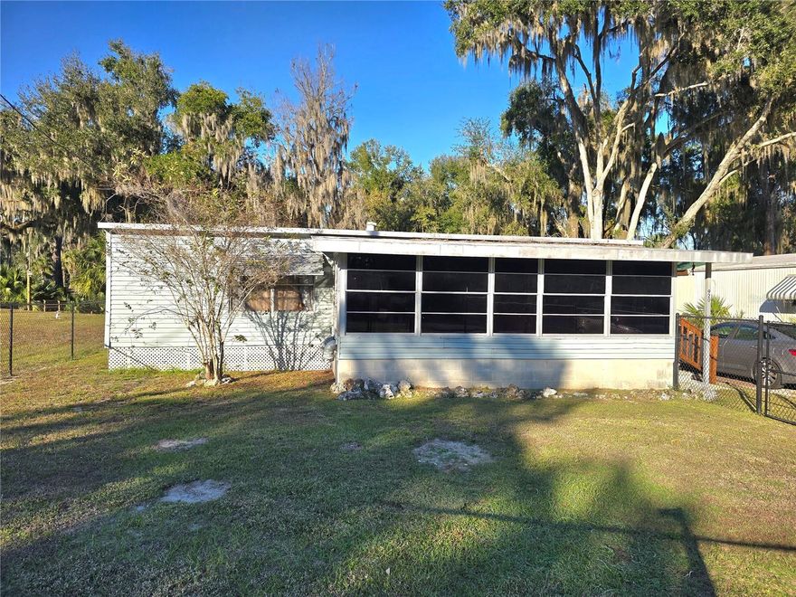 This 2 bedroom 1 bath double wide mobile with enclosed Florida room and back deck sits right on Big Bass Slough. You have your very own wood dock on the water so you can fish from home or hop in your boat and head down to the end of the canal to Lake Panasoffkee, where you will find Bass, Shellcrackers, Crappie and more! Great fishing & the most incredible sunsets just outside your door! And you're just down the road from Big Bass Grill & Big Cypress Pizzeria - some of the best food around! This home is being sold furnished, making it turnkey and ready for you to move in. Home is roofed over and includes a storage shed with outside laundry. New LVP flooring in living area, carpet in bedrooms could use some updating. NO HOA, public water, recently pumped septic. Whether you are looking for a starter home, a winter retreat, or just a get-a-way place on the water, you will want to schedule to see this one soon!