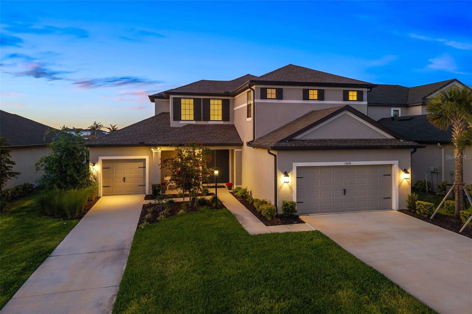 WOW is the WORD to describe this Modern Luxury Home where an AMAZING design meets Resort-Style Living! Welcome to 16626 Paynes Mill Drive, a rarely available TORTOLA MODEL in Park East at Azario, Lakewood Ranch. This stunning 5-bedroom, 4.5-bath home offers 3,461 sq. ft. of thoughtfully designed living space, including a BONUS ROOM, 3-car garage, and versatile flex areas to fit your lifestyle. Perfectly situated on a premium LAKEFRONT homesite, you'll enjoy tranquil water views and breathtaking sunsets daily. In this home you'll be prepared for any storm with the security of knowing you have BACKUP POWER with a built-in GENERAC Generator System and a upgraded gutter system to push the water away. The extended lanai SETS THE TONE for resort-style outdoor living, featuring upgraded travertine flooring, a spacious SALTWATER POOL with HOT TUB and LED lighting, 4 large electric roll-down shades for privacy and ambiance, and a built-in vented gourmet gas grill—ideal for entertaining or relaxing in your own PRIVATE OASIS. Inside, the large GOURMET KITCHEN impresses with 42” soft-close cabinetry, high-end MONOGRAM appliances, upgraded quartz countertops, subway tile backsplash, gas cooktop with stainless hood, built-in wall oven and microwave, a walk-in pantry, and designer pendant lighting over a LARGE CENTER ISLAND. The gathering room features a beautiful DOUBLE TRAY ceiling, expansive WINE WET BAR for entertaining, upgraded POCKET CORNER SLIDERS, and PANORAMIC lake views through your CLEARVIEW SCREEN. The first-floor primary suite offers serene lake views and a spa-inspired bath with dual vanities, soaking tub, and dual rain shower heads, plus oversized walk-in closets. An additional en-suite bedroom is also located downstairs. Upstairs, discover three more spacious bedrooms (one with an en suite), a shared full bath, and a bonus/game room featuring a second WINE WET BAR with lake views (currently used as a theater room). Live where luxury meets lifestyle—lush landscaping, pristine lakes, and the natural beauty of Lakewood Ranch surround you. This home is a true standout—schedule your private showing today!