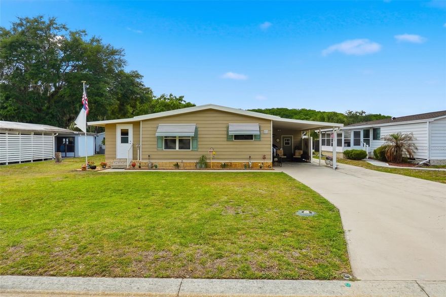 Beautifully maintained 2-bedroom, 2-bath manufactured home with a spacious office/den located in the desirable Timberwoods Estates community. This home offers high ceilings, crown molding, and engineered hardwood flooring throughout the main living areas.
The kitchen comes fully equipped with all appliances and features wood flooring, a pantry with convenient pull-out drawers, and ample storage. The dining area includes custom built-in shelving and drawers, while the living room is bright and open with a ceiling fan and seamless access to the 8x13 sq ft den/office and is fully under heat and air and can be used as hobby room, or additional living space.  The primary bedroom is light and airy with new carpet, a ceiling fan, and a walk-in closet. The fully remodeled en-suite bathroom features a new vanity, granite countertops, updated cabinetry, and a large walk-in shower. The second bedroom offers a ceiling fan, new carpet, and a spacious closet.  Bathroom two has been renovated with new flooring, vanity and lighting.  Step outside to enjoy a covered carport, two storage sheds (including one designed for a golf cart), and a nicely maintained flower bed. The home also features a sprinkler system with a new control box and a durable metal roof. Major updates include an A/C system approximately 2.5 years old and a water heater replaced in 2026.  The community features a clubhouse, tennis courts, pool, golf, restaurant, pickleball, boating, fishing, bocce ball, RV storage and much more.  The community is close to major highways, shopping and The Villages.  Make you appointment today.