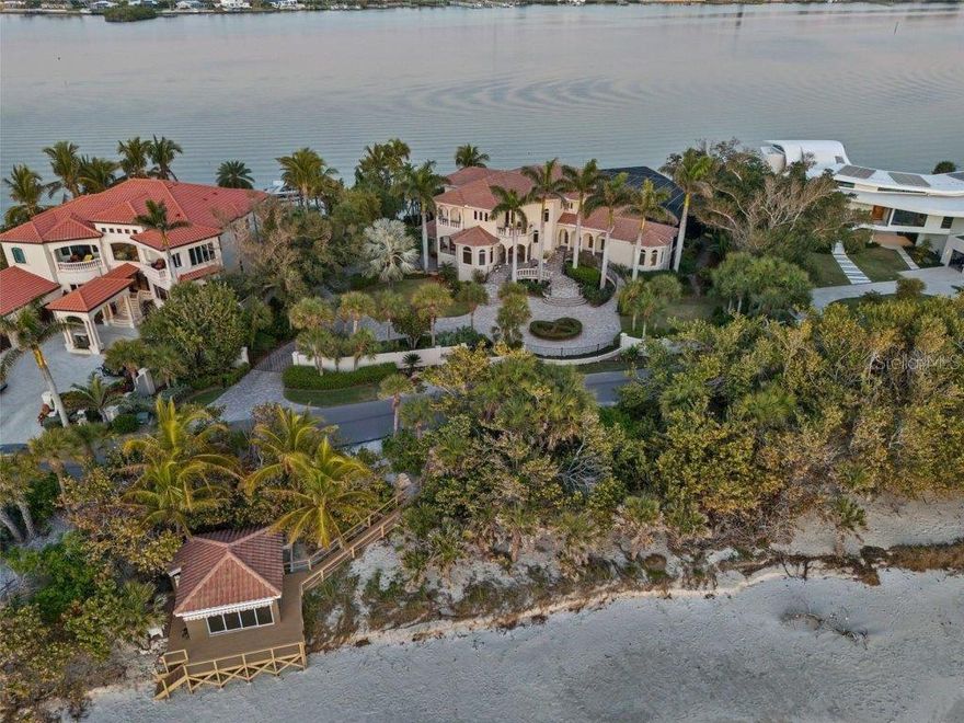 Unveiling a once-in-a-lifetime opportunity to own an unparalleled slice of coastal luxury. Welcome to Pretiola Sands Estate, a secluded and gated haven sprawled across 1.4 acres of lush grounds, boasting an impressive 200 feet of private shoreline on both the Gulf of Mexico and the Intracoastal Waterway. Experience the awe-inspiring vistas of the Gulf and Bay from every vantage point of this meticulously designed family compound. The main residence is built like a fortress on 91 pilings. It is separate yet connected to guest quarters and steps away is a Gulf-front cabana, creating an idyllic retreat for family gatherings and entertaining guests. The essence of resort-style living comes to life with a grand screened recreation area featuring a sparkling pool, a 5-hole putting green, and numerous sitting and dining areas calling you to unwind and savor the tranquil beauty of the Intracoastal Waterway. And for the avid boater, a private dock with a covered boat lift awaits for effortless maritime adventures. Step inside to experience unparalleled luxury and craftsmanship. A beautiful foyer adorned with a granite waterfall leads to the formal dining room and cozy sitting area, both offering Gulf views. The expansive family room, adorned with a charming fireplace, invites you to bask in the serenity of bayfront living. The heart of the home, a chef-inspired kitchen, features Neff international design cabinetry, top-of-the-line appliances, and a breakfast nook bathed in natural light. Adjacent, a wet bar with icemaker and wine chiller ensures seamless entertaining, while the bayside lanai beckons with a gas fireplace and built-in grill for alfresco dining. Retreat to the luxurious Gulf-side primary suite conveniently located on the first level with a massive closet and bayside bath. boasting panoramic Gulf views, a bay-side bath with custom dressing room, and heated floors for ultimate comfort. Meanwhile, guests will delight in the separate guest quarters offering privacy, bamboo flooring, a kitchenette, and a full bath. Upstairs, there are four additional bedrooms, a movie theater, nursery, and convenient laundry facilities. The ground level presents a spacious 3-car garage with ample storage and convenient elevator access to all levels. But the epitome of island living awaits at the charming beach cabana, where a living room, outdoor shower, and dressing room await. Hurricane-rated glass sliding doors seamlessly blend indoor and outdoor living, and Wi-Fi ensures comfort and convenience. The home, itself, sustained no storm damage. The photo of the beach cabana is pre-storm. It has been restored and upgraded.