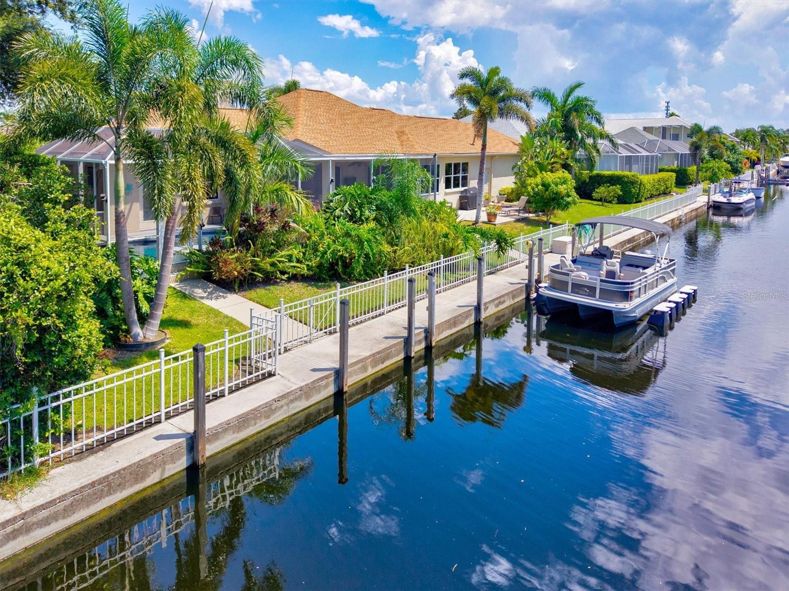 One-of-a-Kind Custom Waterfront Home | Oversized 12,763 Sq. Ft. Lot | Premier Boating Community - The Inlets. Perched on a private cul-de-sac and an exceptional waterfront lot, this stunning custom-built home is designed to live large and entertain with ease. A rare opportunity for a second home, income-producing property, or full-time Florida dream retreat — offered partially furnished. From the moment you enter through the grand double doors, you're greeted by an open-concept great room with soaring ceilings, custom wood floors, crown molding, plantation shutters, and a cozy gas fireplace — perfect for relaxed evenings. The split-bedroom design offers privacy for all, with the luxurious primary suite on one side and guest bedroom on the other. The newly remodeled chef’s kitchen is a showstopper — featuring quartz countertops, neutral backsplash, high-end stainless steel appliances, custom wood cabinetry with built-in organizers, and a wine refrigerator to impress your guests. Retreat to your spacious primary suite with direct access to the lanai and pool. The ensuite bath is pure indulgence, with porcelain tile, quartz counters, custom closets with built-ins, and a spa-inspired walk-in shower. Outdoor living shines with a newly expanded saltwater pool, oversized screened lanai, and private dock ready for your boat. The pool deck, lanai, and front entry feature a heat-resistant, non-slip epoxy flake coating for beauty and function. Love to sunbathe? There’s plenty of space to lounge and enjoy serene water views and unforgettable sunsets. Additional features include: Oversized 2+ car garage with extensive built-ins — a car enthusiast’s dream, custom gated dog run for your four-legged family members, Extended driveway and double Porte Cochere for ample parking. Ring doorbell and security system as well. Located in The Inlets, a premier boating community on the banks of the Manatee River with deep water access just minutes to the Intracoastal and Gulf of Mexico. Enjoy cruising to nearby islands, restaurants, marinas, and yacht clubs. Community amenities include tennis, kayak launch, fishing pier, social events, and waterfront parks. Conveniently located: 2.5 miles to I-75, 10 minutes to Ellenton Premium Outlets & Lakewood Ranch, 20 minutes to World-Class Gulf beaches. Dreaming of waterfront living? This is it — where luxury meets lifestyle. Schedule your private showing!