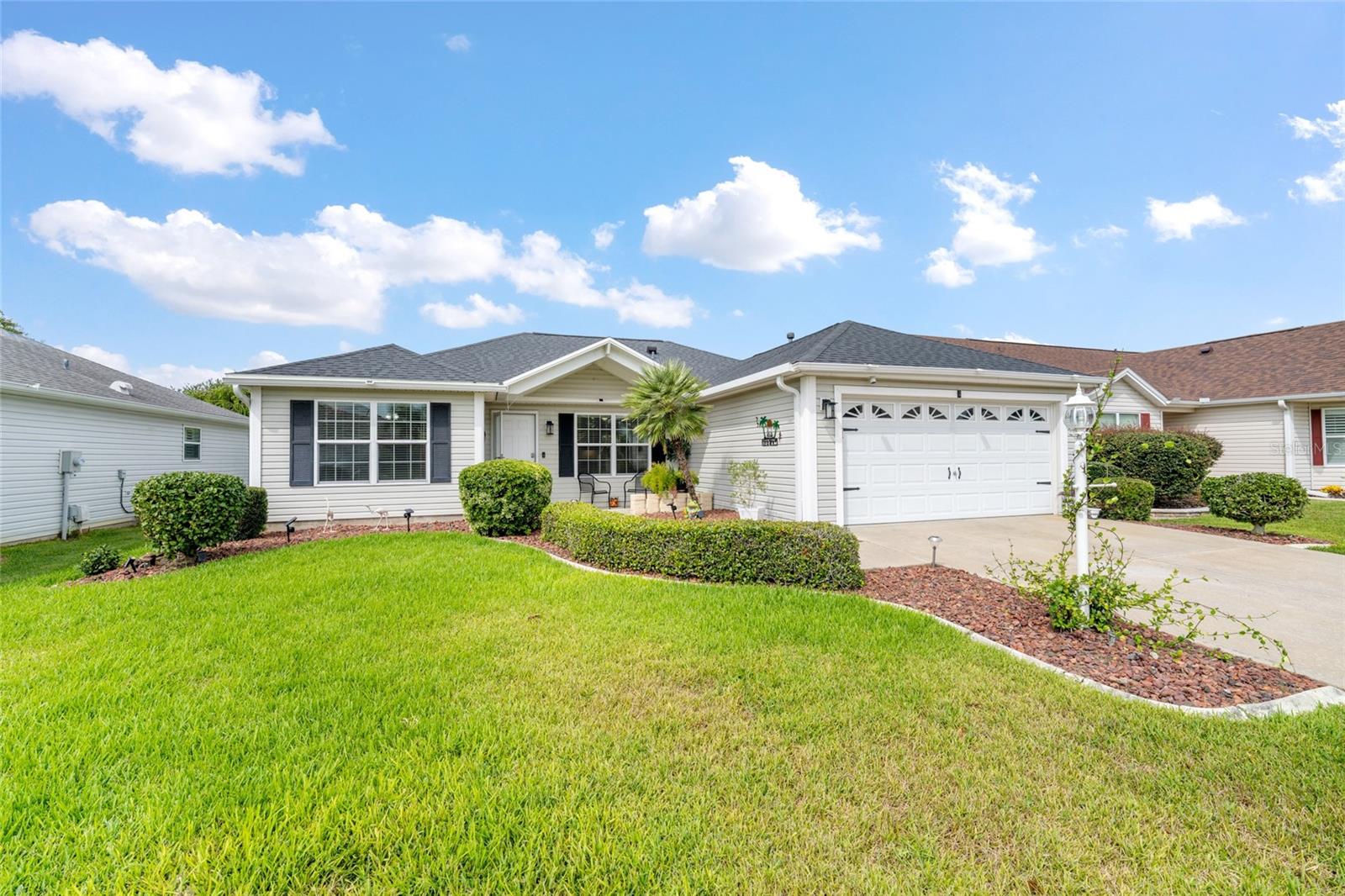 Can you believe the price of this UPDATED 3/2 Bougainvillea (formerly Banyan) Model which is MOVE-IN READY in the desirable VILLAGE OF PIEDMONT near Lopez Country Club? What's important- ROOF 2022, HVAC 2016 AND WATER HEATER 2019. The front curb appeal is so inviting with lava rock and mature landscaping leading to the covered porch. There has been a recent addition of the pitched front porch roof extension to provide cover of the front door. This makes this model unique as compared to similar ones. As you enter, you notice the OPEN FLOOR PLAN and CONTINUOUS LAMINATE FLOORING (no carpet!) with the comfortable living area front and center. The kitchen has been made bright and inviting with NEW GRANITE, FIXTURES and light toned cabinets. The stainless appliances were replaced in 2019 except for the new dishwasher (2024). The kitchen also boasts TILE BACKSPLASH, Solar Tube, and Under-Cabinet Lighting with a GAS STOVE! The Primary Bedroom is spacious with en-suite and a large walk-in closet. The bathroom has a tile floor and updated walk-in shower, linen closet, and the same beautiful Granite counter. The Guest Bedrooms are comfortable and inviting with ceiling fans and both have closets. There is an updated guest bathroom with tub/shower combo and linen closet between them. The large laundry room (inside) has a pantry and storage cabinets and leads to the 2 car garage with additional storage space in the attic and added cabinets. The lanai/enclosed Florida Room with glass/screens is cool and comfortable with roll-up blinds and an attached television which conveys with the home. It leads to an extended birdcage area with canopy for shade which provides extra seating and an entertaining option with new lighting. This area leads to outside for gardening and grilling with a new hose attachment. The backyard area is surrounded by mature landscaping to provide privacy from seasonal neighbors. You will be thrilled with the easy access to shopping, dining and the well-known Villages Squares! You're minutes away from many pools, recreation centers, golf cart path and Savannah Performing Arts Center. This is such a nice home and priced to sell. Make an appointment to see it today- you won't be sorry! (Some of these photos have been virtually staged)
