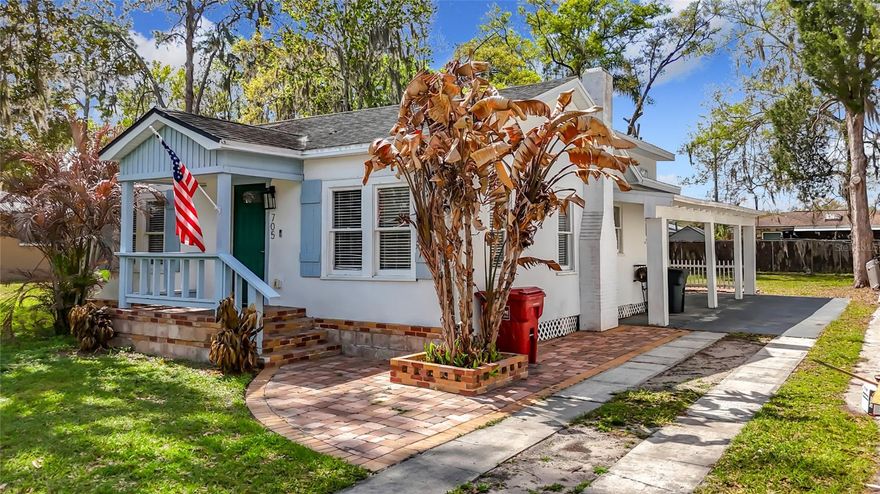 This updated home in Plant City offers a practical layout with modern finishes. The main living area is open and connects directly to the kitchen and dining space. Wood-look flooring runs through the living room, while tile flooring is used in the kitchen.
The kitchen features white shaker cabinets, granite countertops, stainless steel appliances, a tile backsplash, and a large breakfast bar that opens to the living area, which has crown molding. Pendant lighting and recessed lights provide good workspace lighting.
The home includes 3 bedrooms with carpet and ceiling fans. The primary bedroom has an ensuite bath and sliding glass doors that lead to the backyard. The primary bathroom has been updated with a double-sink vanity, granite, and a walk-in shower with tile surround.  This home also has washer/dryer hookup inside.
Outside, the home has a covered front porch, a backyard with space for outdoor use, and plenty of parking. The property sits across the street from Gilchrist Park and is just a 0.7-mile walk to Historic Downtown Plant City and all it has to offer.