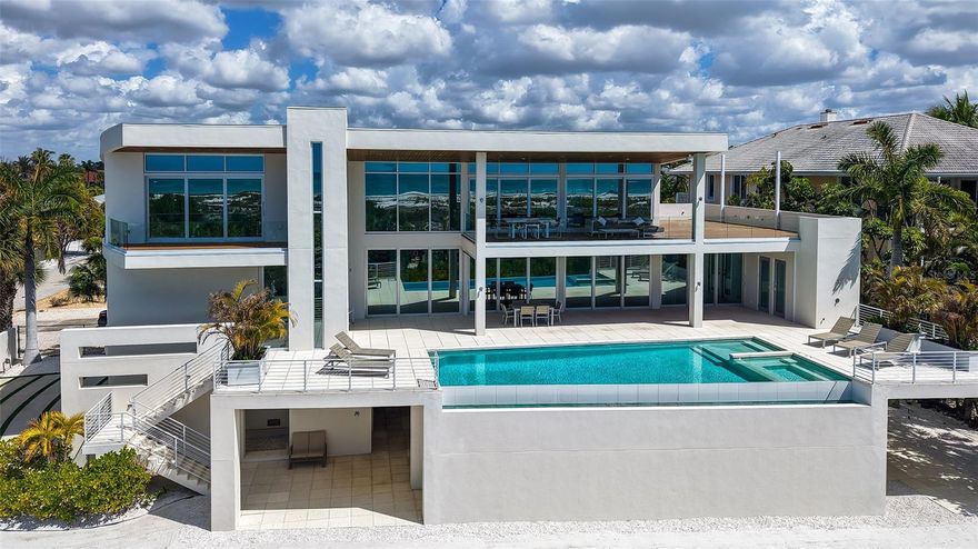 DIRECT GULF FRONT Modern Estate with 135 ft. of private beachfront on Lido Beach. This gated 3-story residence offers 4,751 sq. ft., with 5 bedrooms, 5 baths, 2 half baths, and unobstructed panoramic Gulf views from every level. Expansive terraces, floor-to-ceiling glass, and seamless indoor-outdoor living highlights the coastal lifestyle.

Designed for flexibility, both the 2nd and 3rd floors include full living, dining, and primary suites—ideal for multigenerational living or rental income potential. The 2nd-floor lanai features automated screens, an infinity-edge pool & spa, and open sundeck. The 3rd floor offers a vast living space, wet bar, large sundeck, and a luxurious primary suite with dual sinks, soaking tub, separate water closet with bidet, and a large walk-in shower and closet. 

Premium features include a 3-car garage, elevator, 1,300 sq. ft. storage room, generator, Crestron Home automation, Sonos sound system, motorized shades, gas appliances, zoned A/C, and advanced security with surveillance.

Just a short walk to St. Armands Circle and minutes to Downtown Sarasota, this exceptional property combines architectural excellence, privacy, and world-class beachfront living.