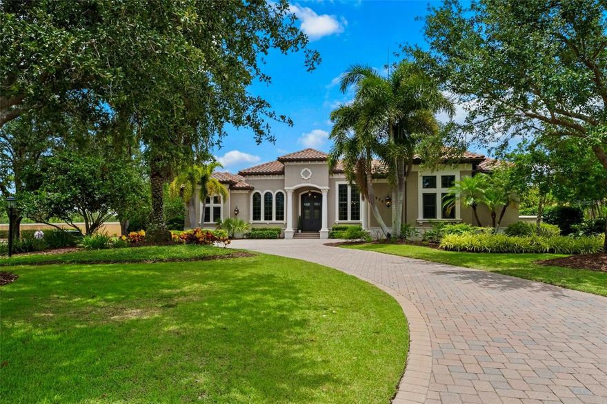 This spectacular Lakewood Ranch Country Club residence built by John Cannon—offering three bedrooms and three-and-a-half baths—is perfectly situated on an estate-sized corner homesite of more than three-quarters of an acre, surrounded by pristine gardens and lush landscaping. Upon arrival, you’re greeted by magnificent iron doors that open into a grand, open-layout living area where tray ceilings, crown moldings, and beautiful French doors frame a dramatic floor-to-ceiling stone fireplace, setting a tone of refined elegance. The gourmet kitchen is both beautiful and functional, boasting striking wood cabinetry, gleaming quartz countertops, and high-end appliances that include Wolf and Thermador ovens, a Sub-Zero refrigerator, and a built-in wine cooler. Whether you’re preparing a casual meal or hosting an elaborate dinner party, this kitchen delivers performance and style in equal measure. Entertainment reaches new heights in the state-of-the-art home theater, where a 128-inch curved masking screen by Stewart Screens, 4K Sony projector, and invisible in-wall Klipsch surround-sound system immerse you in every scene, while plush leather recliners ensure ultimate comfort. When it’s time to unwind, the expansive master suite awaits, complete with custom closets and a spa-inspired bath featuring a frameless glass shower, deep soaking tub, and dual vanities. Two additional guest suites, each with their own private bathroom, offer luxury and privacy for visitors. Step outside to discover a 2,200-square-foot screened lanai laid in gorgeous wood-look tile planks, where a saltwater pool and spa invite refreshing dips and relaxation. An outdoor kitchen provides the perfect backdrop for alfresco dining and social gatherings. Meticulous construction details—including foam insulation, a Generac backup generator, and LED lighting controlled by an integrated Crestron smart home system—ensure comfort, efficiency, and peace of mind. The climate-controlled third garage adds practical convenience, rounding out a home that truly defines country club living at its finest....