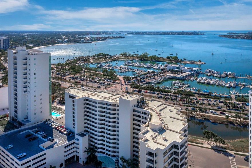 Welcome to Bay Plaza! Located in the heart of downtown, where breathtaking water views meet the vibrant pulse of downtown lifestyle. This distinguished residence delivers elevated amenities that include a grand circular motor court with valet service, attendant garage parking, and fine concierge service. Step outside and immerse yourself in Sarasota’s acclaimed culinary, arts, and cultural attractions. This 4th-floor home showcases expansive western bay and city skyline vistas from its spacious floor plan. Spanning 1,629 square feet, this residence features two generously sized bedrooms, two bathrooms, separate dining room, and two private terraces. Upon entry, discover expansive, light-filled living area framed by floor-to-ceiling hurricane impact-rated sliding doors and windows. The seamless flow continues to the tiled terrace that provides sweeping views of Sarasota Bay, Marina Jack, the iconic Ringling Bridge, and the city’s glittering lights – a perfect setting for entertaining. The extended galley kitchen offers solid counter tops, stainless steel appliances, wood cabinets, extra storage, and a convenient desk or sitting nook. The kitchen, with its adjacent dining area, is ideal for hosting family and friends. The generously-sized owner’s suite offers direct access to the private terrace, along with two closets, dual vanities, a soaking tub, and a walk-in shower. The thoughtfully designed split floor plan also includes a guest room and bath, offering a peaceful retreat for visitors. Bay Plaza offers a lifestyle enhanced by services and amenities including 24-hour valet parking, front desk attendants, on-site property management, and a beautiful lounge and library area. The fully equipped fitness center, complete with a sauna and steam room, provides ultimate relaxation. The heated pool and spa, combined with a community recreation area and covered grilling station, ensure that every day feels like a vacation. Convenience is key at Bay Plaza, with assigned parking, extra storage, bicycle storage, and EV charging stations available for residents. The prime location provides exceptional walkability, with easy access to the waterfront boardwalk, diverse dining options, and the rich cultural events of downtown Sarasota. Experience the pinnacle of waterfront living at Bay Plaza, where location and lifestyle blend seamlessly to create an extraordinary home.