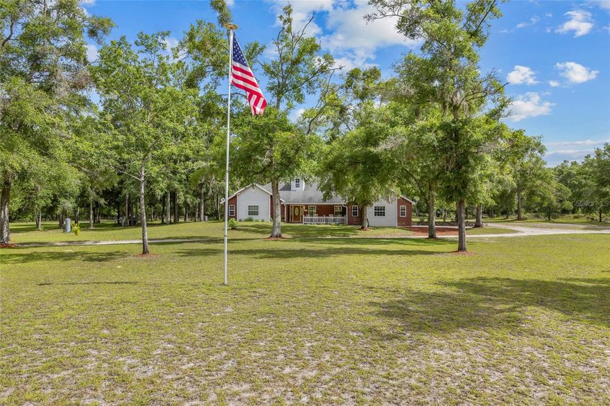 Expansive 20-Acre private estate with custom concrete block home - where space, privacy, and versatility come together on this stunning 20.08-acre property, made up of two 10.04-acre parcels. The custom-built, concrete block home with a charming brick veneer sits on the front parcel, while the second, fully buildable 10-acre tract stretches out directly behind—ideal for a future guest home, investment build, or simply to enjoy as your own wooded retreat. Spanning over 3,662 square feet of heated and cooled space, the residence features 4 bedrooms, 3.5 bathrooms, and plenty of flexible living areas. Inside, you’ll find a spacious living room centered around a floor-to-ceiling stone fireplace, a kitchen with newer stainless steel appliances, breakfast bar, and an accent stone wall that adds warmth and charm. The formal dining room offers ample space for entertaining, and a large bonus room could easily serve as a home office, playroom, gym, or additional living space. The master suite is privately situated on one side of the home, boasting its own stone fireplace, large walk-in closet, dual vanities, walk-in shower, and a relaxing garden tub. On the opposite side, three guest bedrooms offer plenty of room for family or visitors—two bedrooms share a bathroom with double sinks, while the third bedroom includes a private bath and its own entrance, making it perfect for an in-law suite or guest quarters. Additional features include a laundry room, half bath, and an attached two-car garage. Outside, the fully fenced property is scattered with majestic oak trees, a private dirt bike track for outdoor enthusiasts, and plenty of cleared space around the home while the back 10 acres remain nicely wooded—perfect for nature walks, hunting, or total seclusion. No HOA, low Columbia County taxes, and easy access to some of Florida’s best natural treasures—just minutes from the Ichetucknee and Santa Fe Rivers, local springs, and a short drive to High Springs or Gainesville for dining, shopping, and medical facilities. Whether you're looking for multi-generational living, a peaceful homestead, or future investment opportunities—this one-of-a-kind property checks all the boxes.