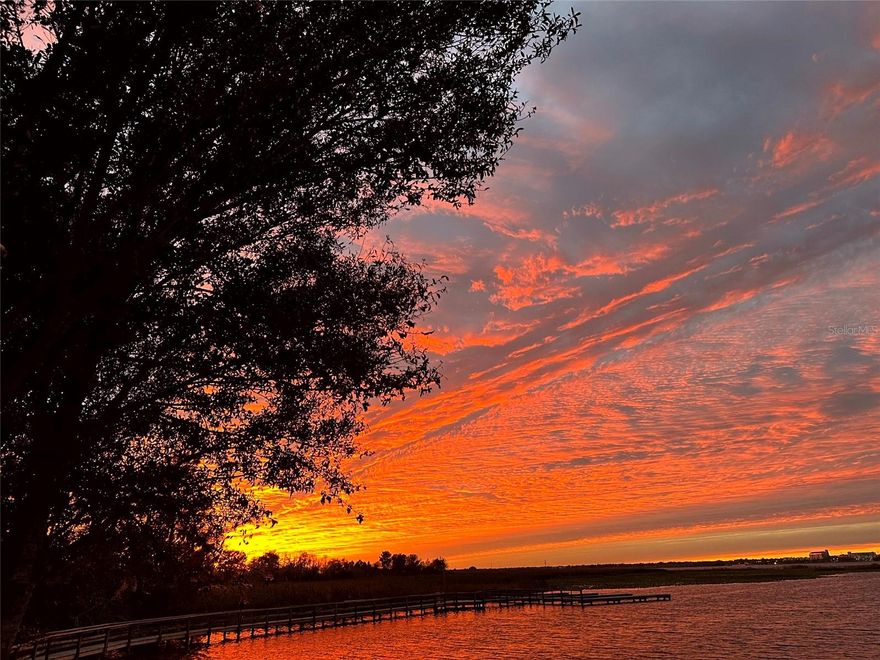 Florida is rated #1 by Kiplinger as the best state for retirement, but Central Florida has so much more to offer! This custom home, located in Sunset Pointe on the shores of West Lake Tohopekaliga, is adjacent to a conservation area/passive park and is connected by a walking/biking path to historic Downtown Kissimmee, where you can catch a SunRail train to downtown Orlando/Winter Park, launch a boat from the marina, take in entertainment at the lakefront park, indulge in local dining, enjoy the nightly fireworks on the horizon from the attractions, celebrate the 4th of July with a spectacular view of the City fireworks, or catch the SpaceX launches from the front yard. You will enjoy the privacy, security and convenience of a small, secluded, gated custom home community just minutes from DISNEY/UNIVERSAL/SEA WORLD, the ORLANDO INT'L AIRPORT, and COCOA BEACH. Take in breathtaking Florida SUNSETS as you lounge on the lanai overlooking the lagoon-style saltwater pool and hot tub overlooking the lake, with fountain and waterfalls. The low maintenance exterior of the home boasts a barrel tile concrete roof and genuine Tennessee fieldstone. The primary suite features dual walk-in closets and vanities, a deep jetted tub, shower with dual heads/slide bars/seat and direct access to the lanai. The updated kitchen boasts upgraded appliances with double oven and microwave, cast iron Kohler sink, prep island, instant hot water dispenser, wine rack, pull-out trays, tilt-out trays and granite countertops. The spacious utility room has built-in cabinetry w/desk, utility sink, solid surface countertops, washer/two dryers, and built-in ironing board and laundry hampers. Additional highlights include spacious 12' ceilings throughout, transom windows, bay windows, crown molding, architectural trim with tray/coffered ceilings, a gas ventless fireplace, 3 bookcases, custom louvered shutters and abundant storage. The home boasts a 3-zone energy-efficient A/C system and 80-gallon hot water heater with recirculating pump, water filtration system with ozonator, carbon filter and softener…purified water with no expensive water bills! The garage measures over 1500 sf with 3 oversized doors (10x10 and 12x13), 12' and 14' ceilings, and a deep center bay for an RV/boat/antique car. It's also wired for EV charging and offers ample storage space, including abundant shelving, two huge closets, a utility sink/cabinet above and attic storage. Room for all your tools and toys!! Indulge in the ultimate entertainment experience with surround sound prewiring in the family room and primary bedroom, speaker prewiring on the lanai, intercom system with door chime and in-wall/ceiling speakers with volume controls throughout the home. Smart wire and dimmer switches, Google Nest(R) doorbell, LED lighting and automatic night lights provide some of the latest technology and conveniences. If you enjoy spending your leisure time fishing, boating, bird/nature-watching, playing pickle ball or simply relaxing by the lagoon-style saltwater pool, you won't want to miss the opportunity to own this custom home of unparalleled quality and luxury. No expensive CDD fees and not in a flood zone!