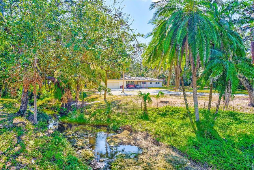 Escape to tranquility with this incredible 4.79-acre property, offering a rare opportunity to own a private oasis in the heart of Tampa Bay. Surrounded by abundant wildlife and a natural, spring-fed creek, this serene retreat brings you closer to nature while still being in the middle of it all. Located down the street from the intracoastal waterway and only 2 miles from our award-winning beaches, this expansive property is ideal for creating your dream family compound or private estate. The existing, four-bedroom, three-bath ranch home has been exceptionally maintained and is move-in ready. Complete with original terrazzo floors, huge back porch, cozy, wood-burning fireplace and a full bath with shower in the garage (it's a Florida thing). Enjoy the rustic charm of the on-site smokehouse, ready for your fresh catch of the day. Capture your own water from the natural artesian well. Take a nature walk - on your own property - with many species of birds visiting daily. This property offers many possibilities for developers, builders and investors. Zoned (RL) residential low, within the city of Largo, allowing 5 homes per acre.  RL allows for single family, single family attached (townhomes) and multifamily.  Located in a non-flood zone. There aren't many properties left like this in Pinellas County - it's a true Old-Florida gem that will capture your heart.