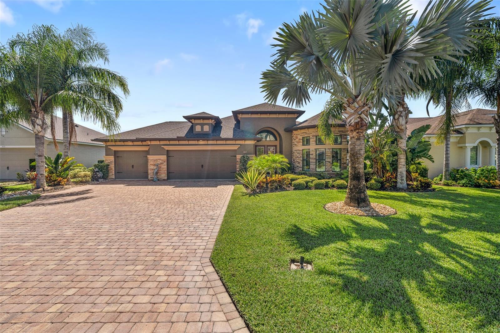 Welcome to this beautifully maintained executive POOL home in the prestigious Plantation Bay Golf & Country Club. From the moment you arrive, the pavers driveway and double glass door entry set the stage for a grand interior filled with light, elegance, and upgrades. Step inside to soaring ceilings with tray and crown details, leading into an open floor plan perfect for both everyday living and entertaining. The deluxe kitchen features built-in GE stainless steel appliances, granite countertops, 42-inch wood cabinetry, tile backsplash, reverse osmosis system, a spacious island, and a large walk-in pantry. Adjacent breakfast nook with plantation shutters and a formal dining room with vaulted ceilings provide ideal spaces for gatherings. The family room impresses with tile floors, high ceilings, and triple sliders with electric blinds that open seamlessly to the lanai capturing the perfect pool and lake views. . The primary suite is a true retreat with views of the pool and lake, grand in size, double walk-in closets, and a spa-like ensuite with dual sinks and a walk-in tile shower. Two additional bedrooms offer comfort for family or guests, each with plantation shutters, large in size, and generous storage. Bedroom 3 has a beautiful curved wall of bay windows overlooking your perfectly manicured front lawn. Outdoor Living at Its Best! The showstopper of this home is the screened lanai and pool oasis, overlooking the lake and lighted fountain for breathtaking views day and night. Enjoy the sparkling pool with ozone system and Jacuzzi with propane heater, or entertain in style with the outdoor kitchen featuring sink, fridge, ice chest, and granite countertops. Pavered decking and a mega-screen enclosure complete this resort-style retreat. Additional highlights include a 3-car extended garage with epoxy flooring, built-in shelving, hybrid hot water heater (2021), whole-house Kinetico water filtration system, surge protection, NEW AC (2024), and updated Minka lighting. Enjoy the unmatched lifestyle of Plantation Bay Golf & Country Club-golf cart friendly community, offering optional membership packages with 45 holes of championship golf, two clubhouses with dining-one being brand new 30 million clubhouse, wellness and spa center, fitness, 9 tennis courts, 10 pickleball courts, a resort-style pool and lap pool, cabana bar and grill, walking trails, and full activities calendar! Buyers of this home to receive a substantial discount on initiation fee at the club. Ask listing agent for details. This home is truly clean as a whistle, move-in ready, and perfectly designed to enjoy Florida living at its finest.