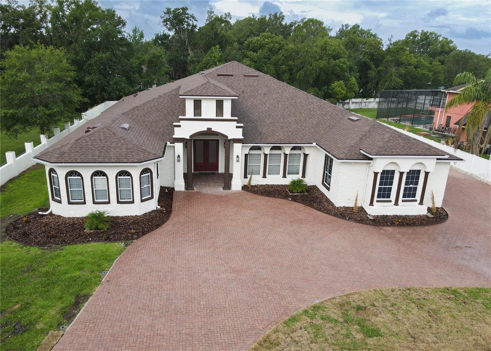 Welcome to this custom-built luxury residence offering 4 bedrooms, 4.5 bathrooms, and 4,370 sq. ft. of living space over a half-acre lot with no HOA restrictions. Designed for comfort, and entertainment, this elegant home is a rare find in the heart of Kissimmee. This is a turnkey home with space, upgrades, and a prime location—ready to welcome its new owner.
Step inside to a flawless floor plan and discover a grand master suite with tray ceiling, dual walk-in closets, and a spa-inspired bath featuring a jetted tub, walk-in shower, and dual split vanities. Each additional bedroom offers its own walk-in closet and private or semi-private bath, providing convenience and privacy. The open-concept kitchen boasts stainless steel appliances, granite countertops, wood cabinetry with crown molding, two pantry closets, and a snack bar that flows seamlessly into the family room and dinette. A formal living room with a built-in wet bar sets the stage for entertaining. The floors are finished with a superior ceramic tile throughout the house, ensuring both style and durability.
Outside, enjoy a screened lanai with half bath, and a large backyard. A perfect combination for private parties or family gatherings. A very elegant and unique attribute is the extended brick-pavers driveway; together with an oversized 3-car garage, will allow to park up to 10 vehicles The home also features a brand-new roof (2025), fresh exterior paint, gutters, a newly renewed irrigation system, a private well with new pump and water softener, septic system recently serviced, and two AC units in excellent condition.
Located just minutes from Lake Buena Vista, world-famous Theme Parks, Orlando International Airport, shopping, dining, and major highways, this home offers both convenience and privacy. Without HOA, you’ll have the freedom to truly make this property your own. Great for a family or an investor. Don't miss it!