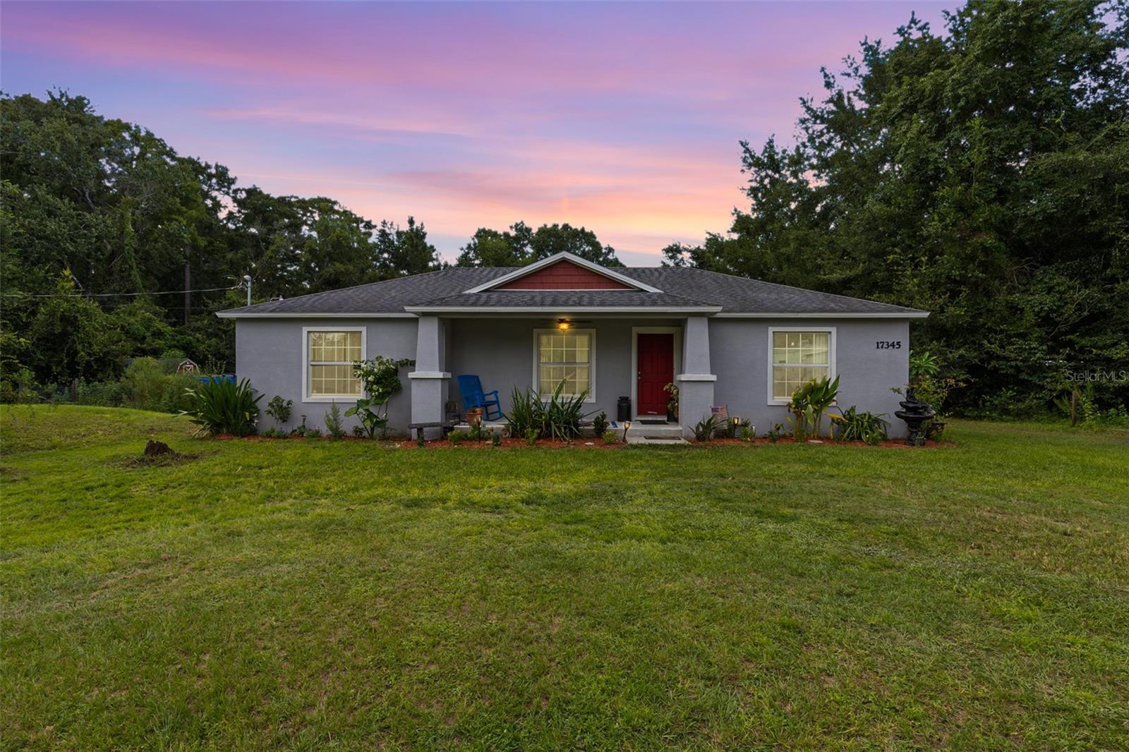 Welcome to 17345 Valencia Drive, a modern country escape where comfort and sustainability come together. Built in 2016, this 3-bedroom, 2-bathroom home sits on more than two acres of land, offering room to spread out, grow, and live the lifestyle you’ve always imagined. Step inside to find an open-concept floor plan centered around an oversized kitchen with expansive islands, perfect for entertaining and family gatherings. Large windows invite natural light, while plenty of storage and thoughtful design details make daily living easy and efficient. Outdoors is where this property truly shines. Surrounding the home is a lush collection of fruit trees and edible plants, turning your backyard into a personal orchard. Enjoy cherries, lemons, oranges, persimmons, Japanese plums, kumquats, mangos, bananas, moringa, chestnuts, grape vines, and even a rootbeer plant, all thriving on your land and ready for seasonal harvest. Whether you’re sipping fresh-squeezed juice on the front porch or enjoying fruit straight from the tree, this property delivers a farm-to-table experience right at home. The expansive patio overlooks the woods and mature trees, creating a private and peaceful backdrop for outdoor living. Additional features include chicken coops, storage sheds, and solar panels that keep electric bills low while maximizing energy efficiency. Here, mornings begin with fresh eggs, afternoons can be spent tending your orchard, and evenings are for watching the sun set over wide-open skies. 17345 Valencia Drive is more than a home, it’s a lifestyle, offering the best of country living just a short drive from modern conveniences.