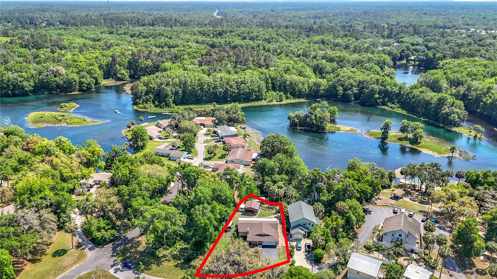 Welcome to your waterfront paradise at the end of the Rainbow River in Dunnellon! This beautifully updated home offers the perfect blend of comfort, style, and riverfront luxury. Step inside to an inviting living room with a cozy gas fireplace, decorative ceiling fans, and durable tile flooring throughout. The chef’s kitchen features granite countertops, updated wood cabinets, tile backsplash, cove lighting, breakfast bar, updated appliances, and a large pantry cabinet—ideal for storage and entertaining. French doors from the dining room lead to a spacious temperature-controlled Lanai/Florida Room (50’ x 8’) with breathtaking river views, perfect for relaxing or hosting guests year-round. The master bedroom features a private walk-in shower, while the guest bedroom is located next to a full bath with tub/shower combo. Both bedrooms have sliding doors opening to the Lanai, creating a seamless indoor-outdoor flow. Step outside to a stunning composite wood deck with solar-lit stairs, leading down to your outdoor entertaining oasis: a 20’ x 20’ covered grilling & dining patio, versatile storage shed (ideal for outdoor kitchen, workshop, or storage), paved dockside patio with firepit area, and private boat dock with covered boathouse & lift. A 2010 16’ pontoon boat with 25HP motor is included, so you can enjoy Rainbow River from day one, with easy access to the Withlacoochee River and Lake Rousseau. Additional features include a newer roof (2023), new HVAC, interior laundry room, coat closet, knock down ceilings, 2-car garage, and a 20’ x 4’ enclosed storage shed. This NO FLOOD ZONE waterfront gem offers the ultimate Florida lifestyle—relaxation, recreation, and room to entertain in your private riverfront retreat. Don’t miss this opportunity to own a piece of paradise on Rainbow River!
