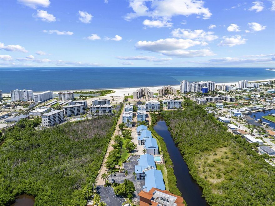 **Trade Snow shovels for Sandcastles! Your Turnkey Island Oasis Awaits** Unbelievable Price for a South End Hidden Gem! Escape the winter chill and step into paradise with this impeccably maintained, fully furnished, move-in-ready 2-bedroom, 2-bathroom condo. Located in the newer Phase 2 building at Admiral's Bay on a quiet street surrounded by lush vegetation, this peaceful retreat is tucked away from the traffic of Estero Blvd on Pine Island Way, yet just a 3-minute walk to the widest white sand beaches of Fort Myers Beach. This spotless unit is designed for effortless Florida living. The kitchen boasts granite countertops, a breakfast bar, a generously sized pantry, and is being sold turn-key. Hosting is a breeze thanks to the smart split-floor plan. The guest bedroom and bathroom are located at the opposite end of the unit with a pocket door for complete privacy. After a day at the beach, come home to the convenience of your own full-size washer and dryer, cleverly tucked away in a closet on the lanai. **Your Private Nature Retreat** Step out onto your screened back lanai and let your stress melt away. Overlooking permanently protected acreage and a canal, this is the perfect spot to enjoy the soothing sounds of the water, listen to the birds sing in the mangroves, and watch for jumping fish. Feeling adventurous? Launch your canoe or kayak! **Resort-Style Amenities & Community** Enjoy a vibrant, welcoming community. As a resident, you have access to two heated pools, tennis courts, pickleball, and shuffleboard. The community's private tiki hut and grilling area provides shade with picnic tables and chairs—making it the ultimate gathering place for morning coffee, happy hours, and scheduled events. Or, relax by the pool before taking a short stroll across the street to take in a glorious Gulf sunset. **Ultimate Convenience** Leave the ice scraper behind! Your reserved, under-the-building parking easily accommodates 2 cars to protect them from the Florida sun. Right next to your lower-level parking is a private extra storage unit perfect for your beach toys. The building features an elevator for easy, stair-free access, as well as underground utilities. **Bonus Features** All assessments have been paid! This is a pet-friendly community, so you can bring your furry best friend along. Bi-weekly rentals are allowed, providing a fantastic opportunity to generate income. With amazing shopping and restaurants just steps away, you have absolute convenience at your fingertips. **Pack your bags, grab your swimsuit, and start living the dream today!**