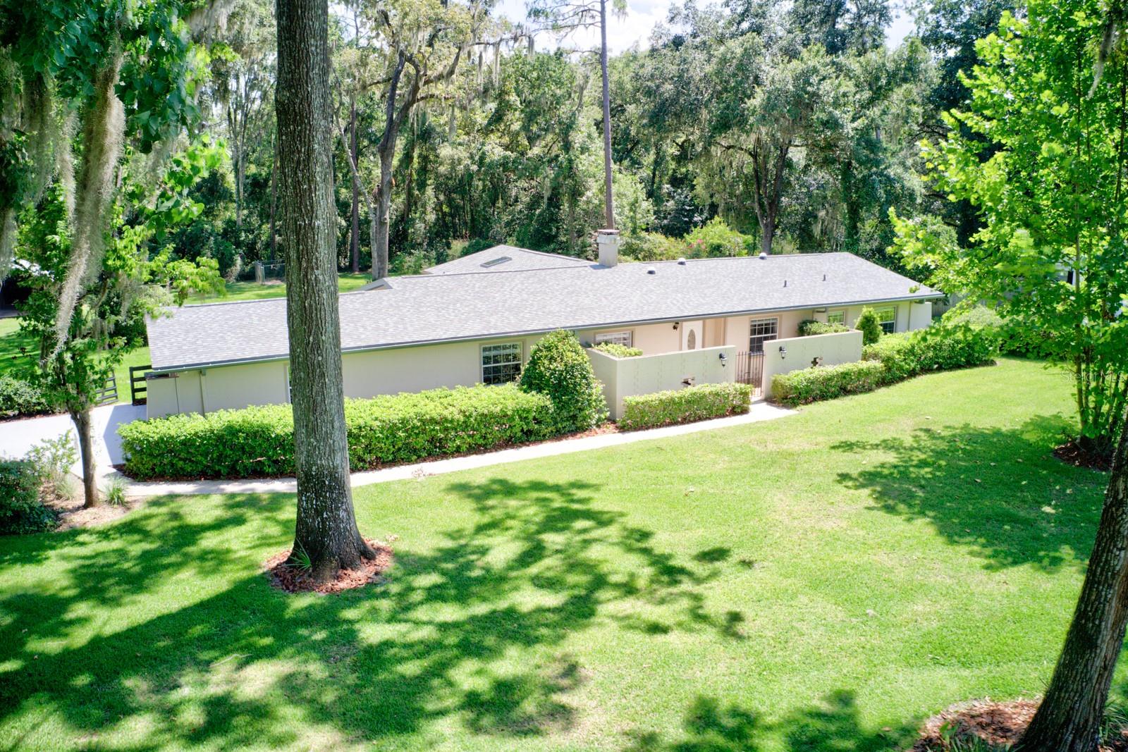 One or more photo(s) has been virtually staged. Discover your oasis in the heart of SW Gainesville with this beautifully maintained 3-bedroom, 2-bath concrete block pool home, offering 1,989 sq ft of living space, an oversized 650+ sq ft 2-car attached garage, and a versatile detached building with power and water. Perfect for hobbyists or RV enthusiasts, the detached building features a 12x25 enclosed workshop with 8x8 roll-up door, a 12x25 covered bay, and a massive 25x40 enclosed space with 8x8 and 10x12 roll-up doors. Nestled on a picturesque 1.33-acre lot with no HOA, the property is adorned by mature oaks and blooming azaleas and features a sparkling saltwater pool, attached 20x16 screened summer kitchen (2020), and an electric side gate. Enjoy peace of mind with recent upgrades including a new roof (2025), driveway (2025), interior paint (2025), newer appliances, HVAC (2022), and water heater (2023). Additional highlights include a chicken coop, fully irrigated yard with well and city water options, and a spacious laundry room with washer and dryer included. Located just minutes from top-rated restaurants, shops, and medical facilities—this rare in-town gem offers both privacy and convenience. Owner financing available with 20% down, 20-year amortization, and an interest rate 2% over prime.