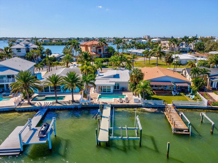 This beautifully updated coastal home offers the perfect blend of luxury, functionality, and peace of mind. Meticulously renovated post-hurricane, the property features impact-rated windows and doors, all upgraded to Cat 5 hurricane code standards. The open-concept layout showcases water views from nearly every room. The kitchen includes granite countertops, wood cabinetry, and vaulted ceilings overlooking the living area and pool deck. The primary suite offers stunning bay views, a walk-in closet, and a remodeled bath with a double vanity. The third bedroom comfortably fits a king-size bed, providing the perfect guest retreat. A dedicated bunk room and playroom combination make this home ideal for families—equally suited for full-time living or as a high-performing vacation rental. The property holds an active short-term rental license and has recently returned to the vacation rental market. Enjoy the Florida lifestyle from your private dock with a 16,000-lb boat lift and jet ski lift, perfect for quick access to waterfront dining or sunset cruises. Additional updates include all-new luxury vinyl flooring, new interior doors and hardware, fresh paint, and updated vanities. Located in a golf cart-friendly neighborhood close to parks, pickleball, dining, and just minutes to Clearwater Beach and downtown St. Pete. Plans for a new custom build are also available—see renderings in photos.
