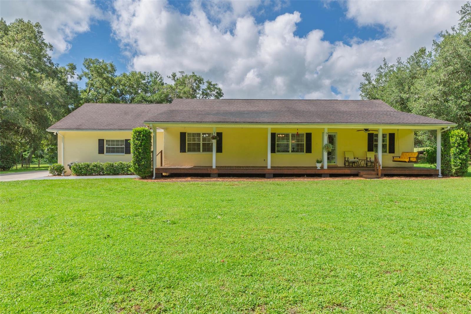 Come experience this hillside 12.72 ACRE estate situated just 3 miles from I-75 offering easy access to Tampa and Ocala. This custom-built, one owner ranch-style home on 12.72 acres offers elevations over 150' dotted with majestic grandfather oaks, fertile pasture grass, and paved county road access. Zoned Agricultural-Residential with NO HOA or CDD FEES! This is the first time this well-maintained home has been for sale. The property has a winding CREEK, with a bridge, that flows through the property. The RANCH-STYLE HOME is approximately 1,856 sq ft with 3 bedrooms, 3 baths plus a BONUS ROOM (all under air). The bonus room, which is located off the double car garage, offers a full bath and private entrance making it perfect for an IN-LAW SUITE, FITNESS ROOM, or HOME OFFICE. The home offers an open-concept floor plan with living room, dining room, kitchen and a split-bedroom layout designed for privacy. The long, wide, relaxing 8'x 52' front porch is the perfect place for drinking your morning coffee while watching the birds and enjoying the peace and quiet of this beautiful homestead. Home is equipped with extra insulation which contributes to lower electric bills. A deep well supplies excellent water to this home and property. The PROPERTY spans 12.72 +/- acres of cleared, high and dry pastureland, entirely fenced and crossed fenced in to 4 paddocks. Paved road county access with two separate entrances, ensures easy and convenient entry into the property and barn area. Agricultural zoning allows you to bring your horses, livestock, animals, start your own hobby farm or just escape life’s “hustle and bustle” and come home to this peaceful setting. Mature trees, open pastures and a pristine clear water creek that runs through the property make this property unique. It’s conveniently located to restaurants, shopping, medical facilities, major cities, and other attractions. This property is located just (15 minutes) from Historical Downtown Dade City, (25 minutes) from Tampa Premium Outlets, with all the restaurants & shopping you could possibly want, (40 mins) from Downtown Tampa, and (1 hour) from the World Equestrian Center in Ocala. The 44'x40' BARN features concrete center aisle, tack room, feed room, high roof, electricity, water, and is suitable for storing RV, equipment, feed, or other supplies. Barn could easily be converted to a 4 STALL HORSE BARN. Barn also offers a 30-amp RV hookup. Gardener's shed (11’ x 16’) includes covered storage for lawn equipment. Don't miss the opportunity to own this home and property that has not been previously offered for sale. This is a must-see property! Schedule your private showing today! Co-owner of this property is a licensed Florida Real Estate Sales Associate.