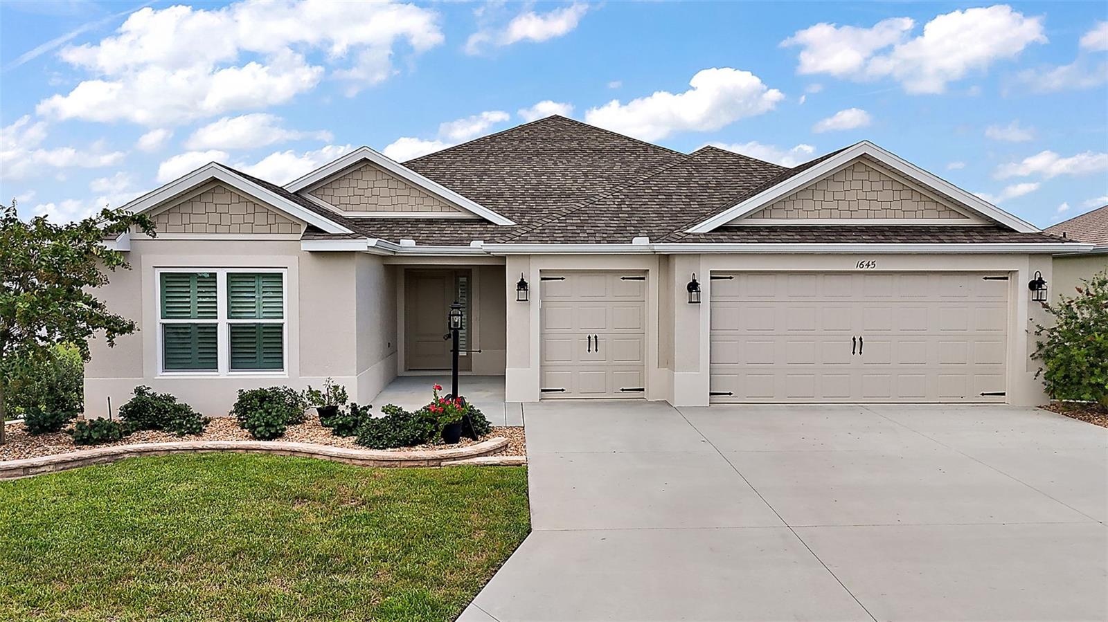 Welcome to this beautifully upgraded DESIGNER MOCKINGBIRD model nestled on a meticulously landscaped corner lot in the VILLAGE OF LAKE DENHAM. This 3-bedroom, 2-bath home features 1,954 square feet of thoughtfully designed living space, complete with elegant finishes.
Step inside to discover TILE FLOORING THROUGHOUT, HIGH KNOCKDOWN CEILINGS, and an OPEN SPLIT FLOOR PLAN that invites both comfortable everyday living and stylish entertaining. The spacious kitchen is a true standout, featuring a breakfast bar, eat-in area, QUARTZ COUNTERTOPS, and ample cabinetry — a perfect place to gather. The living area boasts a ceiling fan and PLANTATION SHUTTERS, continuing the home’s elevated design with 5" BASEBOARDS, and architectural touches throughout. The primary suite is a true retreat, featuring a TRAY CEILING, DUAL CLOSETS, and a luxurious en-suite bath that offers QUARTZ DOUBLE VANITIES, a TILED ROMAN SHOWER, and a private commode room.
Guest bedrooms also feature tile flooring and built-in closets, offering comfort and privacy for friends and family. The fully enclosed lanai is a dream — a 12' x 29' retreat with EPOXY FLOORS and a MINI-SPLIT UNIT, perfect for enjoying Florida's sunshine year-round in comfort. The home also features a two-car garage plus a GOLF CART GARAGE, concrete floors, and excellent extras such as WHOLE-HOUSE GUTTERS, an owned PEGASUS WATER SYSTEM, and an EATON SURGE PROTECTOR for electrical storms.
Ideally located just a short golf cart ride from the family pool at Franklin Rec, this home offers quick access to SAWGRASS GROVE, Ezell Rec Center, and the Clifton Cove Putting Course. You’re minutes from the exciting new EASTPORT area and close to the Southern Oaks Championship Golf Course — everything you love about The Villages, right at your doorstep.