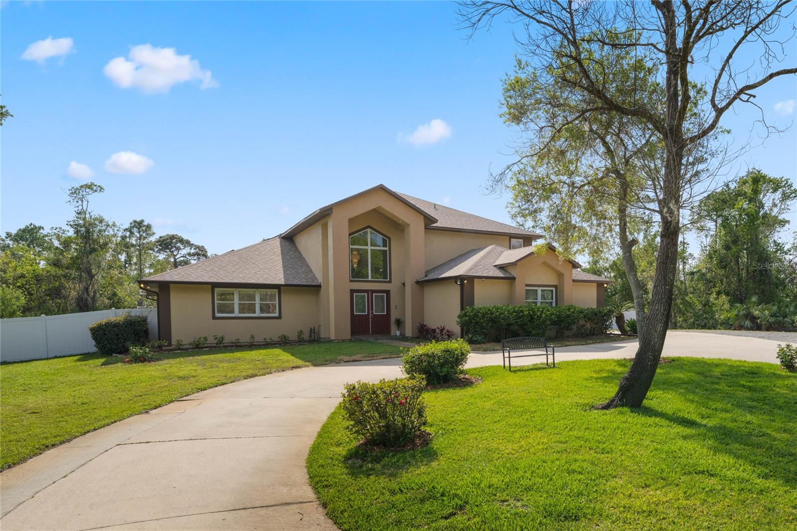 Nestled among the palatial estates and custom homes on the gentle hills of west-central Titusville, Evergreen is a sought-after mature neighborhood known for its beauty and serenity. This hidden gem in Evergreen is situated on nearly 4 acres of wooded homestead created by combining two cul-de-sac lots to ensure truly lasting privacy. A long circular driveway presents this stately home with a side-entry garage and an extensive parking area to easily accommodate all your guests, RVs, and boats. This lovingly updated 3,500 sq ft pool home both embodies the epitome of old Florida charm and features so many new upgrades to ensure worry-free ownership (see attachment). The grand front entry welcomes you with dramatic 2-story soaring ceilings and cathedral windows with gorgeous tree-top views. French doors open to a spacious formal living and dining room. The kitchen is the heart of this home, bridging the formal rooms to the large family room accented with a centerpiece wood-burning stone fireplace. This gourmet kitchen comes complete with a breakfast area, ample cabinets and counter space, built-in double ovens, and a cooking island. On the first floor, there is one bedroom and a flex room adjacent to a beautifully renovated bathroom. An elegant grand staircase in the foyer brings you to the owner’s suite, two spacious secondary bedrooms with a large Jack-and-Jill bathroom, and another bonus flex room. All the bathrooms have been beautifully remodeled with large walk-in showers and luxury features. The home is only half the story. The extensive outdoor living area is complete with a huge covered lanai, a screen-enclosed deck with a new pergola, and an oversized sparkling lagoon-finish solar-heated salt-water pool with a waterfall and a 7’ deep end. This screen-enclosed paradise extends the entire 60’ width of the house! Enjoy the immense private backyard that is completely enclosed with a new PVC fence and two sets of 10’ wide gates. You own all the additional wooded surroundings that offer endless possibilities for future utility and expansions. Enjoy the beautiful sunsets, natural scenery, and rocket launches from the nearby Space Center! Just 5 minutes from the beautiful Fox Lake Park, easy access to Hwy I-95, 40 minutes to Orlando International Airport, and only 1 hour to Disney and Universal theme parks. Pack your boxes, move into this turn-key estate home and start your Florida living today!