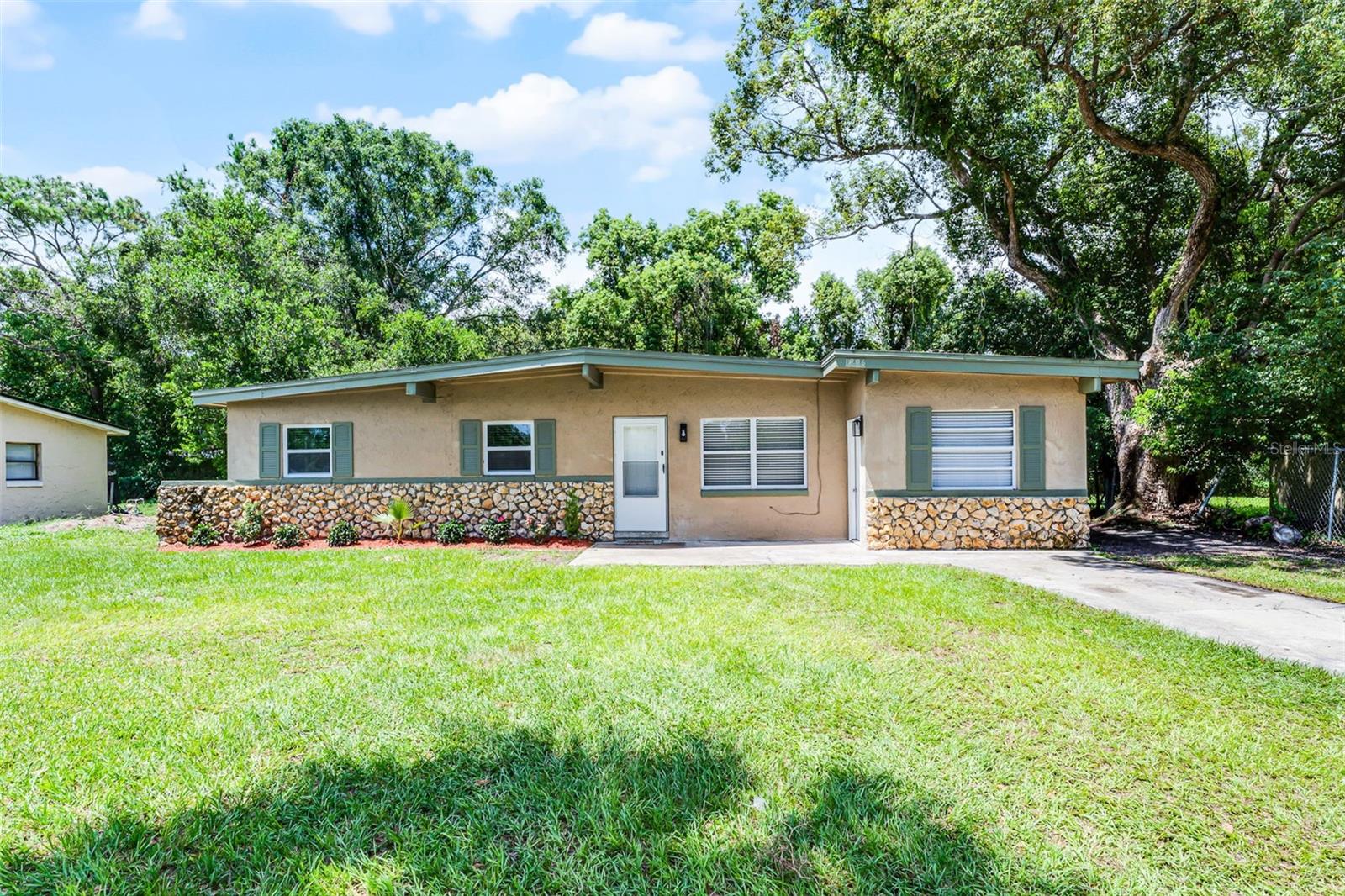 Under contract-accepting backup offers. Welcome to this beautifully updated 4 bedroom, 2 bathroom home tucked away in one of Sanford’s most highly desired NO HOA neighborhoods. Nestled in the heart of town, this charming property sits on an oversized lot surrounded by lush greenery and mature, shady trees that create a peaceful and private atmosphere from the moment you arrive. Step inside and you’ll immediately notice the abundance of natural light streaming through large windows, highlighting the tasteful luxury vinyl flooring that flows seamlessly throughout the home. The spacious living room feels warm and inviting, perfect for relaxing or entertaining guests. Just beyond, the fully equipped kitchen is a dream for any home chef—featuring ample cabinetry, stainless steel appliances, generous counter space, and a deep soaker sink. Whether you’re preparing everyday meals or hosting dinner parties, this space makes it easy. The adjacent indoor laundry room adds convenience and keeps household tasks within easy reach. The primary suite offers a serene retreat with plenty of space, a walk-in closet, and an attached en-suite bathroom complete with a luxurious walk-in shower. Three additional bedrooms and a shared full bathroom are thoughtfully positioned across the home—ideal for guests, home offices, hobby rooms, or play spaces. Out back, enjoy a fully fenced yard with endless possibilities. From weekend barbecues and gardening projects to letting pets or little ones play freely, this backyard is your personal outdoor haven. With limited restrictions, you can make this house your dream home or take advantage of its potential as a prime rental investment. With its central location, beautiful updates, and rare no-HOA setting, this Sanford gem is the perfect blend of comfort, privacy, and convenience. Don’t miss your chance to make it yours!