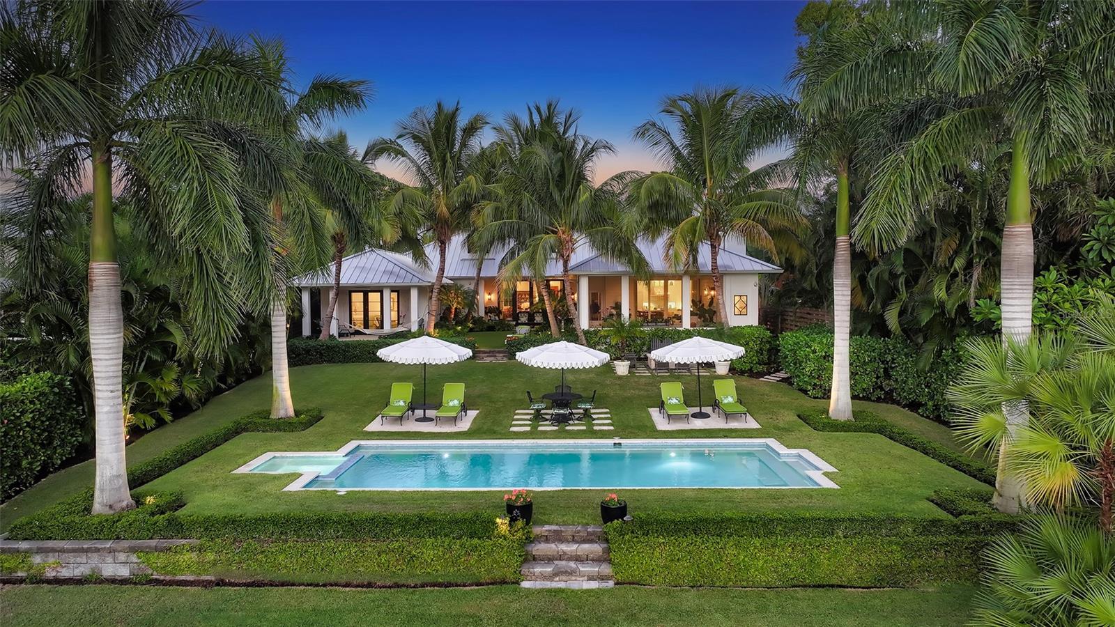 Embrace tranquility and unparalleled luxury in this exquisite waterfront masterpiece, where breathtaking views and stylish surroundings await. Nestled amidst a lush oasis of tropical landscaping, this custom-built 2019 residence seamlessly blends elegance and privacy. Set on an expansive lot with 85' of waterfront, every detail of this architectural gem has been meticulously crafted with the finest quality natural materials such as pecky cypress, Stark sisal rugs, and DuChateau French herringbone oak flooring throughout, creating an atmosphere of warmth and sophistication. Upon entering, you are greeted with soaring ceilings adorned with custom pecky cypress beams which grace the foyer and living room, where 10’ impact doors and windows reveal a stunning view of the picturesque backyard, pool and tranquil waters beyond. The gas-burning fireplace with custom Northern Dominican white coral creates an inviting sanctuary for relaxation and camaraderie.
The gourmet kitchen is a culinary enthusiast's dream with Italian Calcutta Gold countertops, full backsplash, oversized quartz island and top-of-the-line Thermador appliances. A walk-in pantry and 300+/--bottle wine closet ensure you’re always prepared for dinner parties. Adjacent to the kitchen is a spacious casual dining area and family room with 11’.4” ceilings, nickel slot-paneled walls, and access to an expansive screened Florida sunroom with a pocketing wall of glass, where the tranquility of the outdoors envelopes you. A half bath, wet bar and outside pool shower ensure comfort and convenience, while the painted brick wood-burning fireplace adds a touch of rustic charm. The shell-topping floors provide style and durability, and remote-controlled shades offer protection from the elements. Once outside, you’ll bask in the beauty and privacy of serene water views and flourishing tropical foliage. This verdant oasis includes a heated salt-water pool/spa with LED lighting and water fountains, zoysia grass, and an oolite coral fire pit. A newer seal wall and private dock with a 10,000-pound boat lift offer access to the bay for water adventures. The spacious primary suite with sitting area features French doors that open onto a private terrace overlooking the scenic backyard and water. Luxurious dual bathrooms showcase marble floors and walls, walk-in showers, and a soaking tub. A shared outdoor shower provides an invigorating connection with nature, while walk-in closets ensure generous storage. The large den includes built-in custom cabinetry, zoned AC with sound-suppression insulation, French doors, walls of custom pecky cypress, a large dormer for plenty of natural lighting, and a mounted TV with Sonos. The media room boasts vaulted ceilings of painted cypress perfect for entertaining and movie watching, while the 3 en-suite guest bedrooms with walk-in closets offer comfort and convenience and many custom features. The home has two 2-car garages, one of which is detached and could easily be converted into anything you desire. Offering a beautiful blend of refined taste and effortless living all on one floor, your dream home awaits. Don’t miss the opportunity to make it yours.