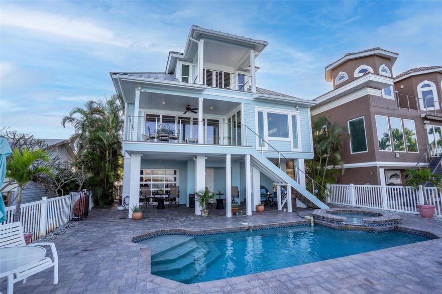 Embark on a journey of luxury and sophistication at 13007 Boca Ciega Ave, a stunning three-story residence that seamlessly combines modern elegance with a rich history. Originally constructed in 1999 and thoughtfully remodeled in 2014, this meticulously crafted home invites you to indulge in a lifestyle of opulence and comfort. Enter paradise at ground level welcoming you to finished entryway with interior staircase, workshop & large storage closet, two hurricane-reinforced garage doors, and an 8-foot-tall tempered glass garage door facing the water. Elevate your living experience with a three-level interior elevator, ensuring accessibility to every floor. The main level unveils breathtaking panoramic views of the intracoastal and Eleanor Island through floor to ceiling accordion slider doors perfect for indoor/outdoor living. Take in the views of this level from the kitchen, great room, and sitting area all with exquisite tile flooring & tongue and groove Cypress ceiling throughout. Or enjoy the daily view of dolphins, birds and boats from the back porch with exterior staircase to the pool. The kitchen has been remodeled to a culinary masterpiece featuring custom white cabinets, Carrara marble countertops, and top-of-the-line stainless steel appliances, including Jenn-Air commercial-grade gas cooktop, double ovens, built in Miele steamer and indulging coffee/cappuccino maker . The sitting/breakfast area extension offers a cozy ambiance with brick enclosed gas fireplace, custom bookshelves, and minibar complete with beverage cooler. Two bedrooms on this level boast ensuite bathrooms, providing private retreats for family or guests. Ascend to the top level, where a luxurious primary suite awaits. Hurricane sliding doors lead to a Trex deck, offering breathtaking views. Enjoy the richness of an oversized custom walk-in closet (8.9x20 ft) with lighted hangers. The master bath is a haven of relaxation with a claw tub and walk-in shower, complemented by custom leaded glass windows. Bonus room off the primary makes for a perfect for office, nursery, library or 4th bedroom overflow for guests. Laundry/vanity/storage area and office space are also located on this level. Step outback to enjoy the pool and hot-tub with captivating view, upgraded pavers, and rebuilt Trex dock over open water. Boat lift is 9,000 capacity and there is also a jet ski lift. Other noteworthy upgrades to the home include new HVAC system, recent exterior repaint, new vinyl hurricane impact and UV resistant windows, and solar powered outdoor shower. Experience waterfront living at its finest with intracoastal waterway out back, Gulf of Mexico right around the corner by boat, paddle to the sandbar, or walk out the front door and be to the beach only a few blocks away. Strategically located footsteps to John's Pass Village and just a short distance from Tampa and Clearwater. Seize the opportunity to make this meticulously maintained home yours. Call today, as it won't be on the market for long!