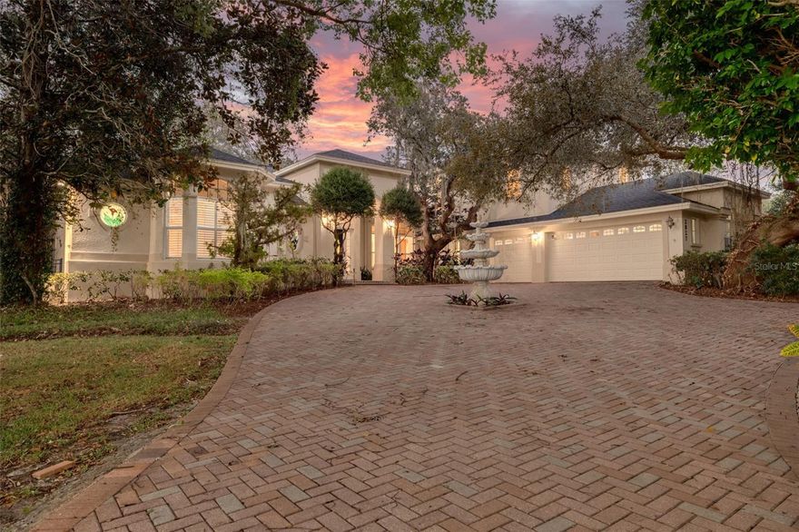Welcome to your private oasis in the exclusive Cypress Lakes Estates! This stunning 4-bedroom, 4.5-bathroom home offers over 4,500 square feet of luxurious living space on an expansive 0.86-acre lot, surrounded by lush landscaping and a canopy of oak trees. A grand circular driveway and three-car garage with built in storage create a memorable first impression. Step through the large French doors into a beautifully designed living and dining area featuring cathedral ceilings, elegant chandeliers, murals, and large telescopic sliders that open to the pool lanai—creating a perfect flow for entertaining. The primary suite, conveniently located on the main level, features his and hers closets and an ensuite bathroom with dual sinks, a garden tub, a walk-in shower, and a private water closet for added comfort and privacy. Adjacent to the primary suite, the sunroom invites relaxation with a gas-burning fireplace, wet bar, and direct pool access. The home office boasts built-in shelving and ample space for working or studying from home. The gourmet kitchen is a chef’s dream—complete with dual kitchen islands, a breakfast bar, a dry bar, multiple prep sinks, stainless steel appliances, a gas cooktop, built in dual ovens, and abundant pantry storage. The kitchen flows seamlessly into the breakfast nook and family room, creating an inviting hub for everyday living. A secondary bedroom with ensuite bathroom is also located downstairs, ideal for guests or multigenerational living. Upstairs, you’ll find two additional bedrooms, a bathroom, a loft area, and a screened, covered balcony—perfect for enjoying serene views of the grounds. Outside, the resort-style pool area features a spillover spa, outdoor kitchen, and spacious lanai, ideal for gatherings or quiet evenings under the stars. The fenced backyard offers plenty of room for gardening, play, or simply enjoying the Florida sunshine. With 30-foot setbacks ensuring 60 feet between each home, you’ll love the peace and privacy this neighborhood provides. Located in one of the area’s most desirable neighborhoods and zoned for top-rated schools, this home combines elegance, privacy, and convenience—all in one exceptional package.