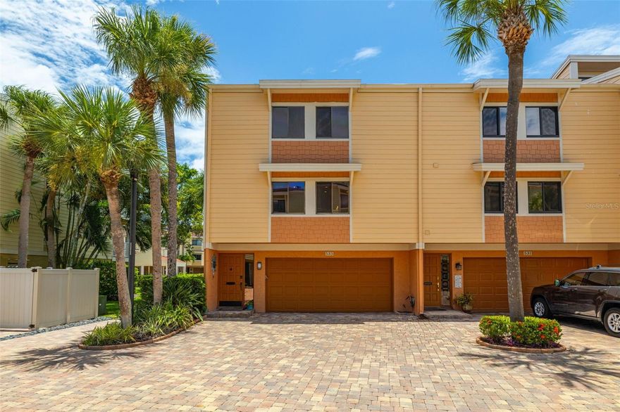 SELLER MOTIVATED!! Welcome to your Treasure Island END-UNIT townhome getaway! Located in the sought-after Village of Paradise Island, this move-in-ready townhome offers the perfect mix of beachside convenience and upgraded everyday living within minutes from Treasure Island Beach. With 3 bedrooms + Flex Space, 2.5 bathrooms, approximately 2025 sqft of living space, an oversized 2-car garage, and a fully finished bonus room, there’s plenty of space for guests, home office, or an additional lounge or media area. The first floor offers a spacious 2-car garage with durable epoxy flake flooring, along with a convenient laundry closet. The bonus room stays comfortable year-round with its own mini-split system and opens directly to a covered lanai, the most ideal spot to unwind after a day on the water, just steps from one of the community pools. The second floor is designed for entertaining with a bright, open layout connecting the kitchen, dining area, and living room. A cozy wood-burning fireplace creates a warm focal point in the main living space. Bamboo flooring (2018) adds style and durability throughout the living areas. The kitchen is both functional and beautifully appointed with granite countertops, stainless steel appliances, and solid-wood soft-close cabinetry featuring smart storage upgrades like pullouts, custom spice organization, and under-cabinet lighting. With two walk-in pantries and a double-oven range, this space is set up for anyone who enjoys cooking or hosting. Outdoor living is a highlight here, with multiple balconies featuring low-maintenance Trex decking, plus a custom metal spiral staircase that provides easy access down to ground level. Upstairs, the private third-floor layout includes the primary suite and two additional bedrooms. The primary retreat feels like a getaway with its own balcony, high ceilings, and an oversized walk-in closet with custom built-ins (2024). The ensuite bath delivers spa-like comfort with dual vanities and an upgraded shower featuring dual shower heads (2018 renovation). Beyond the home, the community offers an unbeatable lifestyle with two pools, ample guest parking, and a deep-water marina and fishing dock, along with over 20 boat slips available. The neighborhood is also pet-friendly and golf cart-friendly, and sits next to Tennis Bay Golf & Tennis, offering golf, tennis, and pickleball nearby. Plus, you’re only a short drive to downtown St. Petersburg for museums, dining, and nightlife. Monthly HOA dues provide excellent value and include insurance, exterior maintenance, cable & internet, water, sewer, trash, exterior pest control, landscaping, and pool service, along with access to the fishing dock. You’ll also enjoy a welcoming, social community with regular events and gatherings. This is your chance to own a beautifully upgraded coastal townhome in one of Treasure Island’s most desirable waterfront communities. Schedule your private tour today!