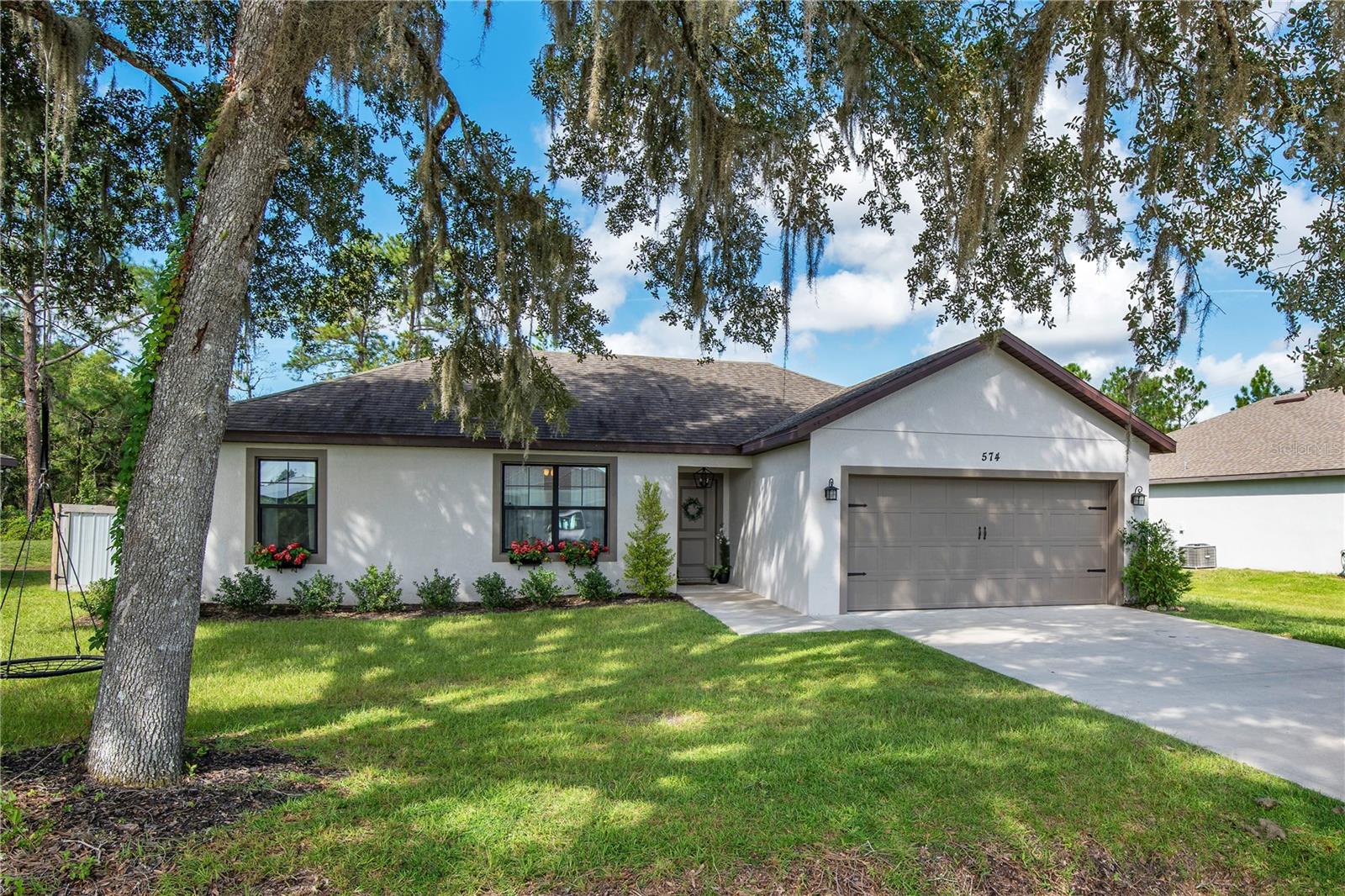 This beautiful home is just as stunning and inviting inside as its picture-perfect curb appeal! Welcome to one of the newest and most charming homes for sale in the peaceful Hontoon Island area of DeLand, FL. Eligible for USDA financing, this is The Drake Model built by Award Winning Pioneer Construction Corp. Step inside and you will instantly feel at home in this bright and spacious 3 bedroom 2 bath split floor plan with a 2-car garage. The open layout is filled with natural light and features high ceilings, beautiful porcelain wood-look tile, and 5 1/4 baseboards that add an elegant touch. The kitchen is truly the heart of the home with granite countertops, custom cabinetry, and plenty of storage for all your cooking and entertaining needs. The backyard is just as special - a fully fenced retreat where you can relax, host barbecues, or simply unwind while enjoying peaceful nature views. Built in 2020, you can move in with confidence knowing the roof, HVAC, septic, and water heater are all brand new and worry-free for years to come. Septic was pumped in 2024 and HVAC serviced in August 2025. Whether you are sipping coffee on the patio in the morning or gathering with loved ones in the open living space, this home was designed to be enjoyed. Do not miss your chance to make it yours - schedule a showing today and start creating lasting memories in this beautiful DeLand home.