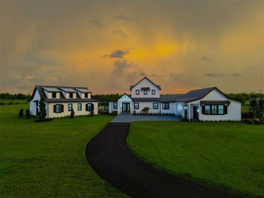 New Construction- Welcome to Big Sky Ranch! WOW... This is a stunning 4 br 4.5 bath, MODERN FARM-STYLE custom home! Truly one of a kind, this custom home demands attention and offers a spacious one level design. Step into the expansive family room and be instantly wowed by soaring 26 foot vaulted shiplap ceilings accented with exposed beams that draw the eye upward. A custom brick fireplace anchors one end of the room, flanked by built-in cabinetry and topped with a dramatic 10-foot ceiling fan. Natural light pours in through the picture windows and two sets of French doors. In the heart of the kitchen, a large T shape island provides ample prep space and seating for six. The kitchen is a chef's dream with high end appliances including a 48 in Wolfe range, double ovens, 2 farmhouse sinks, a pot filler and a wine cooler. Beautiful quartz countertops, subway tile backsplash, custom soft-close cabinets with pull outs complete the look. The dining area accommodates both casual and formal gatherings. Tucked away at one end of the house, the private primary suite offers a peaceful retreat, accessed through a charming galley off the dining room with exposed North Carolina barnwood beams. The primary bedroom features these same rustic touches, while the spa-like bathroom includes dual vanities, a freestanding soaking tub, a huge walk through shower with an overhead rain shower, two wall shower heads, a stunning glass block wall and SeaGlass flooring. The custom walk-in closet is just as impressive. Nearby, the spacious laundry room includes a sink and generous cabinetry for storage. Off of the kitchen, you'll find a large custom walk-in butler's pantry with a sink, abundant shelving and cabinetry, and double frosted glass doors. This wing also includes an office area and a mudroom with a built-in cubby system for the family. The family wing is located left of the foyer through a breezeway leading to three generously sized bedrooms, each with en-suite bathrooms and custom walk-in closets plus a bonus room perfect for casual entertaining or a playroom. Step outside to your backyard paradise with two large brick paved lanais and plenty of space for a pool. Enjoy your morning coffee on the cozy front porch swing . The oversized, attached 3 car side entry garage features epoxy flooring and adds to the home's practicality. Additional features include beautiful LVP flooring, LED can lighting and 8 inch nickel gap shiplap throughout. A 500 gallon propane tank, two tankless water heaters, Kohler faucets and toilets, leather dolomite countertops in secondary baths and laundry, a wireless surround system, custom closets throughout, generator pre-wiring, outdoor kitchen stub-out, and paver trim. A solar powered gate with keypad and exit sensors adds security and convenience. This house has great curb appeal with the brick paved driveway, the custom window shutters, professional landscaping, and that charming front porch swing. This home sits on nearly 5 acres, backs up to conservation land for added privacy, and is zoned for top-rated Randall and Newsome schools with a bus pick-up at the end of Powerline Road. With no HOA, you’re free to bring your boats, RVs, and horses—there’s even room to build a barn.
You will experience some of the most breathtaking sunsets Florida has to offer right here in your own backyard.