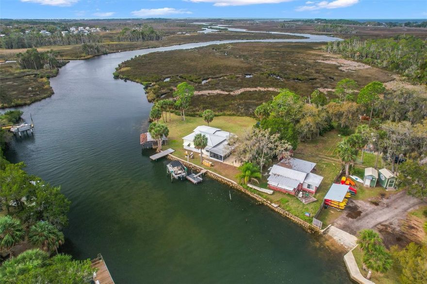 Welcome to PARADISE POINT!! RARELY does something this special and unique come up for sale!!! Located at the end of Mary's Fish Camp Road...this property is literally the last point of land on Mud River as you're heading out to the GULF!! Incredible 200+ feet of RIVER FRONTAGE directly on Mud River with access to the main head spring for swimming with the manatees and dolphins that frequent the river daily!! You CANNOT beat this location!! The location alone is worth it! PRIVATE concrete boat ramp is on the property and grandfathered in!!  Electric boat lift! Fish cleaning station!! Large storage shed!! Wonderful large covered and screened-in lanai!! 2 docks (one stationary and 1 floating) + 2 homes are on the property, connected by an interior foyer for a total of 3 bedrooms and 3 bathrooms!  The main home is decorated in coastal decor to help relax you and put you on river time! The second home is a rustic cabin charm! Enjoy relaxing under the covered, screened lanai as you watch the dolphins and manatees coming through the river! The main home has 2 bedrooms + 2 full bathrooms! It offers an open floorplan with the kitchen, great room, and dining area all open to one another! The home offers granite countertops, real wood cabinets, new luxury vinyl plank flooring, new chair-rail height water-proof walls! Both bathrooms are upgraded and remodeled with real wood shaker cabinets, granite countertops! The attached guest home (mother-in-law home or second home...whatever you want to call it) has 1 bedroom + 1 bathroom + its own kitchen + large living room (half of it is being used as a bedroom area for several) bunk beds! Or build your own large elevated, multi-story home and take advantage of seeing nothing between you and the Gulf of Mexico! Put your kayak in the water from your own boat ramp, or jump on your boat from your own electric boat lift! Go swim in the head spring just a short distance from the property or take your boat out to the Gulf passing Bayport and Pine Island for boating, fishing, and tubing! This property is incredibly unique and can be used as an income-producing vacation home, too!  Come live on Paradise Point and see what peace it brings you with NO NEIGHBORS on 3 sides of you and views as far as your eyes can see! Gorgeous sunsets guaranteed almost all evening!! This is a super exciting property...come see it today!! Owner Financing is available with acceptable down payment and terms.