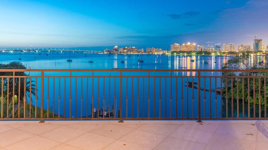 Many have commented that this is the most beautiful home they have ever viewed in Sarasota. Tucked between Harbor Acres & downtown Sarasota in one of Sarasota's most exclusive locations. Deep water harborage & exquisite views of Bay & city skyline are framed by the untouched splendor of Selby Gardens & the iconic Ringling Bridge. A Tuscan inspired tone where no expense was spared, elegant columns flank the grand rib vaulted walkway where soaring ceilings & a wall of French doors showcase unforgettable views. Exotic woods & hand painted ceiling detail headline the superlatives. The kitchen features a stylish circular breakfast alcove, hand crafted walnut cabinetry, honed granite counters, Wolf Professional Range, Miele cappuccino center, an antique butcher's block, & full butler's kitchen. A formal dining room with handsome wine display & 2 story office with leather floors & private library are featured. The master suite overlooking the bay is luxurious, with 2 large walk-in closets, a kitchenette & spa-like bath. 3 elegant guest suites, a gathering room with kitchenette & a theatre are located on the 2nd level. The lushly landscaped gated grounds include a gorgeous 2nd story waterside gazebo with fireplace, a bay front patio with infinity lap pool, spa & stunning rooftop terrace. The elevator services all levels. There are approximately 125 pilings driven 26' into the earth & bedrock that form a strong structural foundation. Parking for 8 cars & an abundance of storage space is found on lower level.