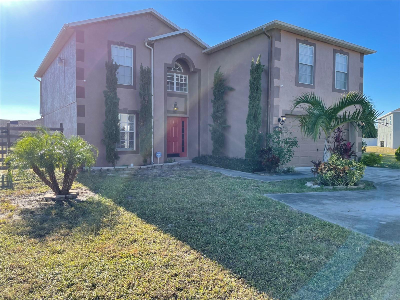 This masterfully crafted residence embodies the essence of Florida living at its finest. Nestled on a spacious, fully fenced ~1/3-acre lot, this home boasts an impressive array of features and upgrades, including wood-inspired flooring throughout, new toilets and faucets, new ceiling fans, ceramic tile and backsplash in the bathrooms, custom framing/woodwork, smart, color-changing recessed lighting in the kitchen, a custom-built movie theater, a custom-built wine rack, and a smart front-door lock with keyless coded entry. The home features 4 bedrooms, 2.5 bathrooms, a versatile loft, and a 2-car garage. The moment you step through the front door of this 2,762 SF, exquisitely appointed home, you’re greeted by a soaring two-story foyer that sets the tone for an inviting and memorable experience. The expansive formal dining room decorated with beautiful custom made wine rack and chandelier is perfect for hosting gatherings. The kitchen is a chef’s delight, featuring crisp white wood cabinetry adorned with a subway-tile backsplash, expansive butcher-block countertop space and a freestanding island, plus stainless-steel appliances—including a refrigerator, range, dishwasher, and microwave—along with a freestanding hood, undermount sink, and oil-rubbed bronze faucet and fixtures. A cozy breakfast nook provides a spot for casual meals or lively family conversations. Beyond the kitchen is the family room, where you can relax with loved ones or step through the sliding glass doors into the sprawling backyard. The first floor is completed by a well-appointed laundry room with a front-loading touchscreen washer/dryer and a beautiful half bath. Ascending to the second floor, you’ll find a luxurious primary suite designed as a private retreat. The ensuite bathroom exudes spa-like luxury with a garden tub, separate shower stall, white penny-tile flooring and backsplash for a classic, elegant look, and walk-in closet for exceptional organization. Three additional bedrooms share a fully upgraded secondary bathroom, thoughtfully designed with double sinks upgraded penny-tile flooring and backsplash and a stylish tub/shower combo. A spacious loft completes the second floor, offering endless possibilities such as a game room or flexible living area. Step outside to your private, fully fenced backyard—perfect for outdoor entertaining, family gatherings, or soaking up the Florida sunshine. The seamless indoor-outdoor flow makes this home an entertainer’s dream. Located in the vibrant Poinciana community, the property offers easy access to major highways, hospitals, medical facilities, dining, and shopping options. This home isn’t just a residence—it’s a lifestyle. Experience the perfect blend of elegance and everyday comfort in this extraordinary home.