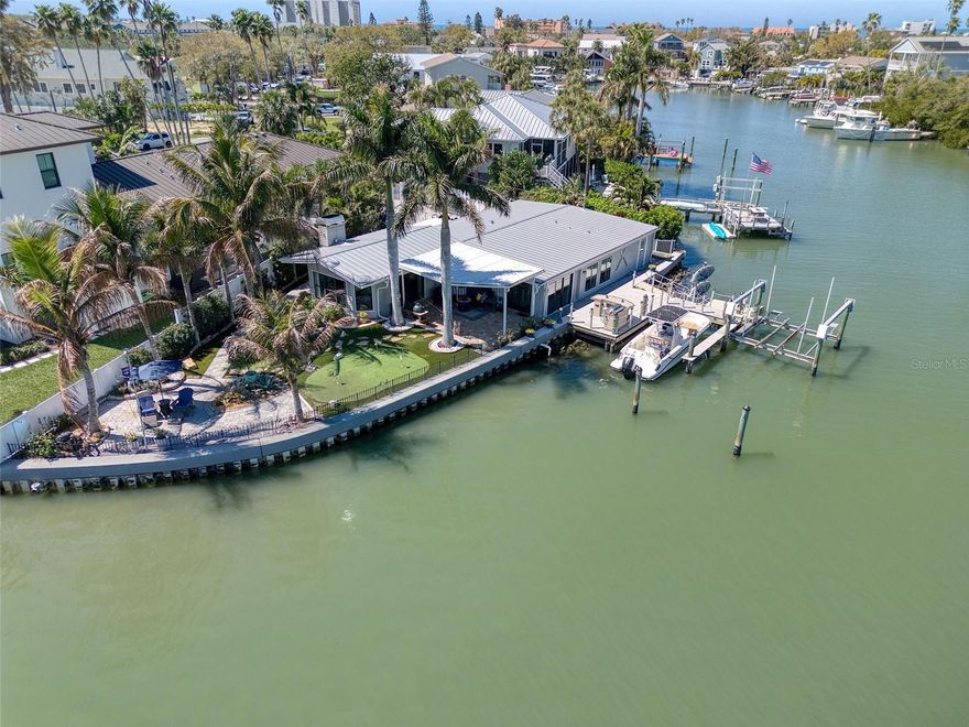 Bright and beautiful aptly describes this pristine 2 bedroom, 2 bath, waterfront home on a secluded cul-de-sac lot in the highly sought after golf cart friendly Indian Rocks Beach. Indian Rocks Beach is one of Florida's most desirable beach communities and is known for it's stunning white sand beach and its friendly, easygoing charm. This coastal home has an amazing 140 ft sea wall (2014) that opens up the home to a stunning water view from nearly every window and the coastal inspired backyard and outdoor patios.  This well laid out open floor plan boasts a welcoming living room, dining room, and a large kitchen with glass mosaic backsplash, quartz countertops, solid wood cabinetry, new stainless steel induction range, dishwasher and stainless steel refrigerator. The primary bedroom suite is spacious and split from the other generous sized bedroom for privacy and has an amazing water view. The hurricane rated sliders from the dining room and living room open up to the awesome backyard featuring a custom paved patio with an outdoor shower, a putting green, outdoor grill and dock; creating a seamless blend of indoor/outdoor entertainment living.  There are several sitting areas in the backyard oasis that are enhanced by the stunning flower gardens and natives plants.  Enjoy your morning coffee on your patio and say "hi" to the dolphins who visit every morning around 7 am. The  dophins come back around 7 pm with the tide. This home has a large deep water slip suitable for a sailboat, a dock with a 20,000 lb boat lift and a floating platform to launch your kayak. There is plenty of storage in the 1 car garage and utility area of the home. This delightful light and bright home is move in ready with tasteful touches such as crown molding, 6" base boards, pristine wood-look tile floors, and neutral color tones all achieved with elegance and great taste. The metal roof was installed in 2015. This home also has reclaimed water for irrigation.  Watch video to experience the beauty of this coastal home. Indian Rocks Beach also allows short term rentals. The location is truly amazing; jump in your golf cart to nearby shops, restaurants, and the beach that are a short walk or bike ride away.  If you love the outdoors there are many recreational activities, from golf to fishing, kayaking and boating. Couple this with excellent schools, pristine beaches and all that fabulous Indian Rocks Beach has to offer and you have the ultimate Florida lifestyle home.