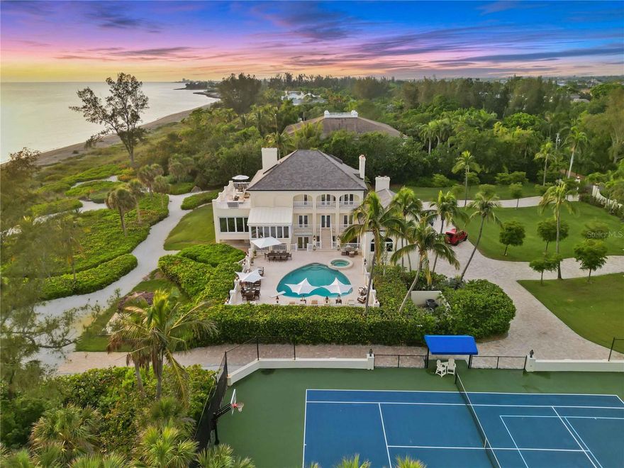 Imagine your very own resort-like estate in the heart of the most sought after community in all of Sarasota!  Sanderling Club is nestled on the south end of the world renown barrier island of Siesta Key.  This ultimate beachfront experience is the true definition of living in paradise.  This property offers the most exquisite home on almost 4.5 acres with over 300 feet of beachfront.  The primary residence with over 8,600 square feet of living space is ideally positioned, capturing the amber skyline and emerald green waterways of the Gulf of Mexico from every angle.  The interior design of this magnificent home is perfect for entertaining with the main living areas and spacious dining room facing the west to enjoy Southwest Florida sunsets every evening.   The custom kitchen features Rutt cabinetry, a large island with plenty of seating, Wolf and Sub-Zero appliances, gorgeous marble countertops accented by brushed gold hardware creating an elegant experience in the heart of the home. The family room creates a warm inviting feeling as soon as you enter the space.  The attention to detail throughout including custom moulding, built in shelving, views of mature tropical foliage, and the sparkling pool create such an incredible ambiance and place to create many fond experiences with family and friends.  The home office, only accessed through a secret hidden door, makes working from home a pleasure.  This property is meticulously well maintained with many recent updates to the main house including: brand new roof installed in 2023, new custom kitchen, beautifully renovated bathrooms, new engineered walnut flooring throughout, elegant marble flooring, custom wood millwork, a butler’s kitchen, LED lighting throughout, newer HVAC systems and ductwork, elevator, exterior patio railings, gated entry, Smart Home Wi-Fi enabled automation, and brand new hurricane impact window and doors installed in 2023.  The private owner's suite is on one level featuring a spa-like bathroom with tranquil water views.  The suite offers a private waterfront terrace and dual custom closets. The two guest suites also offer breathtaking views.  The lower level features another full service kitchen, an additional guest space or gym, two full bathrooms, a steam room, a sauna, an expansive garage, and additional storage room.  The second kitchen is easily accessible to the salt water pool and spa, a lighted tiki hut, outdoor fire pit, tennis courts, and a new paved drive space.  The guest house with over 2,300 square feet of living space was built in 2007 and is a kayaker's dream located on Heron Lagoon with 316 ft of waterfront .  With an open great room plan and high ceilings your guests will feel like they are in a tropical oasis. The guest house has a full kitchen, 2 en-suite, bedrooms, a large screened in terrace, and a large deck leading out to the boat dock.  The dock is ideal for launching your kayak or canoe.  Relax and simply sit on the dock and enjoy the sounds of birds chirping and the sound of palm trees swaying in the wind.  This estate is within the guarded & gated community of Sanderling Club. The community offers amenities such as:  a beach club, tennis and pickleball courts, Paul Rudolph-designed beach cabanas, playground, and dockage on the bay.