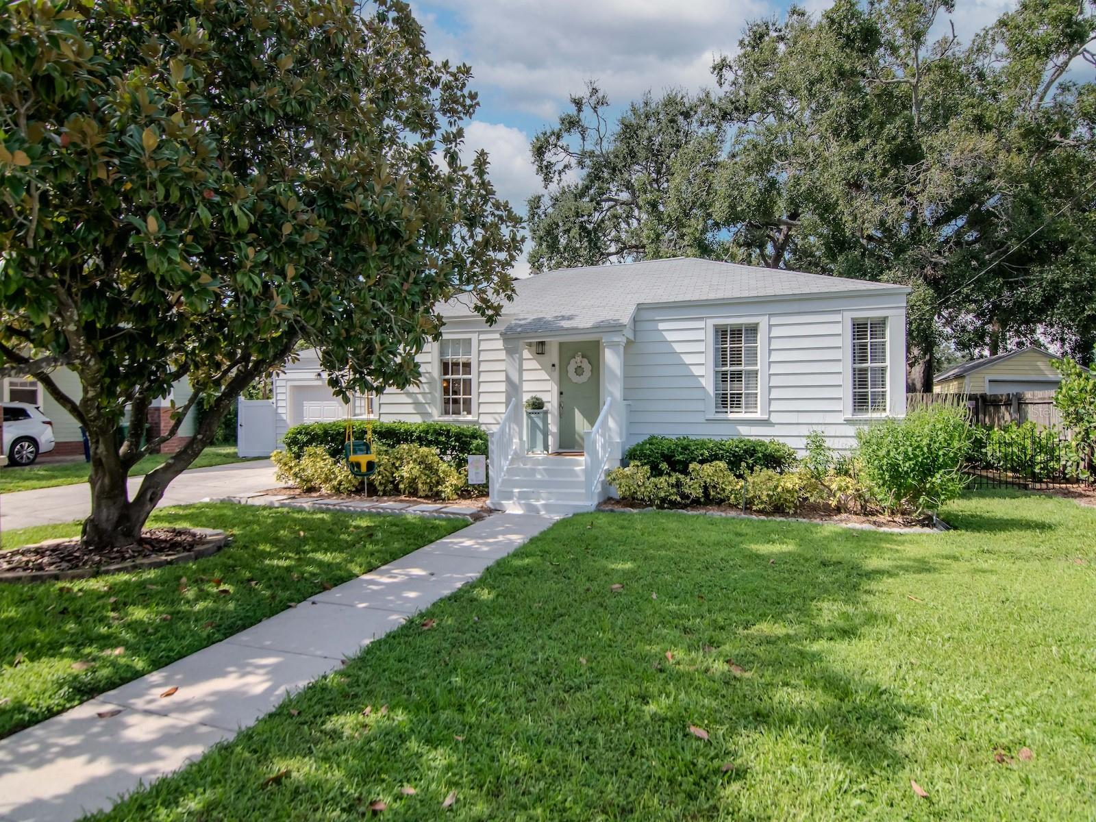 Welcome to this truly special property in prestigious Virginia Park, where happiness greets you the moment you step through the front door. Positioned on a 75x100 foot lot with a stunning magnolia tree in the front yard and surrounded by numerous multi-million-dollar newer construction homes, this home offers timeless charm and rare versatility. The main residence features 2 bedrooms and 1 bathroom with 1,102 square feet of living space, showcasing original 1941 hardwood floors, spacious bedrooms with extra storage, a beautifully updated bathroom with linen closet, and a kitchen updated around 2012 with granite countertops, stainless steel appliances, and ceramic tile flooring. Natural light fills the expansive family room highlighted by a wood burning fireplace with a white stone mantel, while an additional office, playroom, or den provides more flexibility. Just steps away, the detached guest suite offers approximately 441 square feet with a private bedroom, full bathroom, full kitchen, and ceramic tile flooring throughout, complete with a new mini-split AC system and a private entry, making it an excellent opportunity for rental income or extended stay guests. With a total of 1,543 square feet under air, this home combines history, design, and function in one of South Tampa’s most sought after neighborhoods. This property sustained no flooding or damage in Fall 2024 storms. Schedule your private showing today and experience the warmth and possibilities this property has to offer.