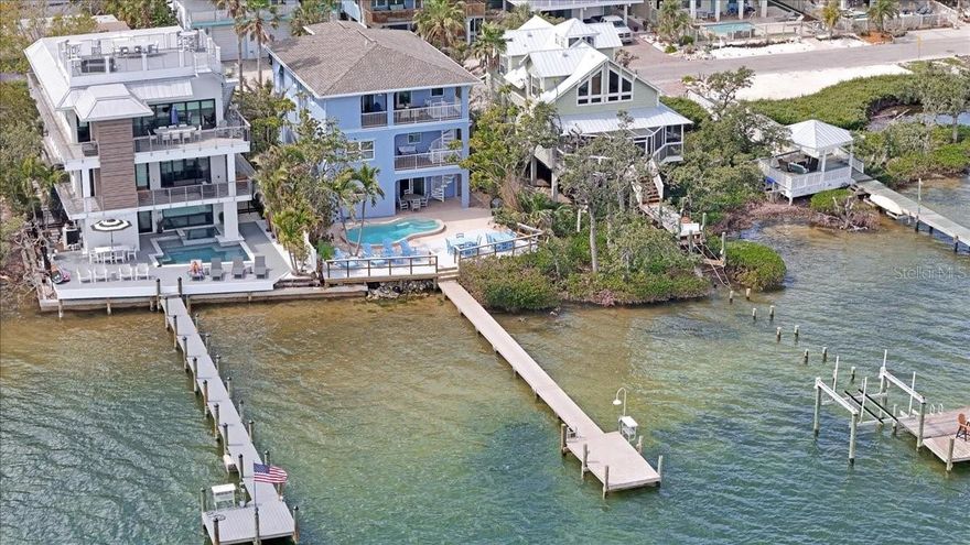 LIVE THE ISLAND DREAM - BREATHTAKING BAYFRONT HOME WITH DOCK, POOL, & WEEKLY RENTAL INCOME!
Welcome to your dream waterfront escape on Anna Maria Island, where coastal charm meets modern luxury! This elevated 3-story bayfront home is fully updated, turnkey furnished, and rental-ready, making it the perfect blend of vacation home + investment opportunity. With expansive open-water views of Sarasota Bay, this property delivers everything buyers from out of town are seeking: sun, sand, salt air - and serious ROI. 

The 4-bedroom, 5.5-bath layout is thoughtfully designed for both relaxed island living and high-end entertaining. Picture this: sipping your morning coffee on one of multiple balconies as dolphins pass by, then stepping out to your private deep-water dock (room for any size boat!) for a day on the water. Inside the home features: Light filled, coastal-inspired interiors, elevator to all floors, spacious great room and kitchen combo, primary suite with water views, bunk room, full laundry, outdoor shower, oversized 4-car garage with pool bath and entertainment space. Outside, enjoy: A newly resurfaced heated pool (2024) and deck (2023), newer roof (2019), pool heater/pump/motor (2023), HVAC (2021), ductwork and water tanks (2023), along with TREX decking and a fish cleaning station. 

This home sits just blocks from the island's famous beaches, restaurants, and shops, with direct access to boating, paddleboarding, and sunset cruising. In a top rental zone with little restrictions, it's a proven weekly rental performer - perfect for those looking to generate income when not in residence. Buyers are increasingly seeking properties that deliver experience, lifestyle, and value. This delivers all three - plus breathtaking bay views from nearly every room AND a pickleball court on your street. Don't miss your chance to own a slice of Anna Maria Island paradise that's built for peace of mind and storm resilience. Offered fully furnished and ready to go - just bring your sunscreen. *Information deemed reliable but not guaranteed.  Buyers or Buyers Agent to verify.