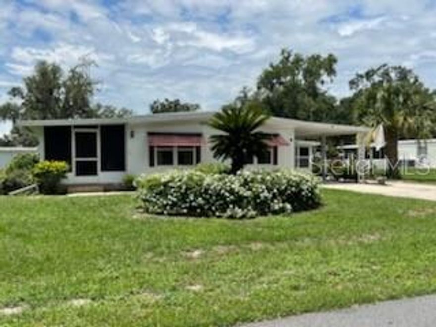 NEW FABULOUS PRICE; Beautifully Maintained Home with Bonus Room and Tons of Updates - Just Minutes from The Villages! This charming, well kept manufactured home features a spacious and flexible floor plan with the potential for 3 bedrooms, offering over 1,700 sq. ft. of total living space, which includes a bonus room that is not calculated in the original footage of the home. Perfect for relaxing or entertaining, this home is move in ready with major updates completed. Some of the interior upgrades include, freshly painted throughout, brand new flooring, new interior lighting, new drywall, newer windows, A/C approximately 5 years old, roof recently inspected and cleaned, also comes partially furnished. Convenient Features are the spacious foyer with room to bring washer and dryer inside plus plenty of indoor storage space. The Outdoor Highlights are, 8x8 laundry/storage room, 8x12 golf cart garage, 8x8 shed for lawn equipment, 9x10 screened front porch perfect for morning coffee or evening relaxation. Prime location, just 3 miles from Brownwood, The Villages. Enjoy free nightly entertainment, shopping, restaurants and more just minutes away.  Our community is located in central Florida, 1 hour east or west you touch the coast, 35 min. north to Ocala, 1 hour south to Orlando and Disney World. We have all the amenities you could want, including that secure feeling with knowing there is a private gated entrance. You'll love living here,  I know because I do.