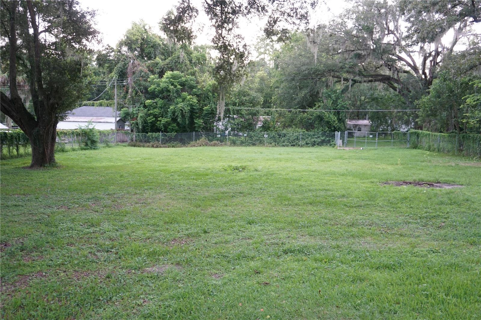 Cleared .39 of an acre lot on a paved road with a power pole, septic tank and 6' chain link fence on 3 sides. Zoning is R4 so you can build a house or have a mobile home set up. This location is conveniently located in Ocala between Hwy 441 and Hwy 464/Maricamp Rd. There is a great savings with the land already completely cleared with nice grass and a couple of oak trees. Needs well, so no water or sewer bill here.