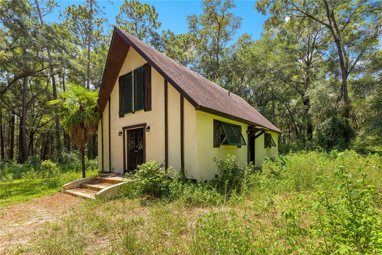Bring your vision and creativity to this unique 3-bedroom, 1.5-bath home tucked away on 1.6 acres of peaceful, wooded land. This property is a true fixer-upper and ideal for an investor, flipper, or buyer looking to rehab and make it their own private retreat. The home features a striking A-frame style with soaring wood ceilings, an open floor plan, and plenty of natural light. The 2024 A/C provides a head start on updates, while the expansive property offers endless opportunities for outdoor living and gardening. With A1 zoning, this property could also be used as a mini farm, giving you flexibility to add animals or cultivate your own homestead lifestyle. Best of all, it’s not in a flood zone, so you can renovate with peace of mind. Conveniently located yet surrounded by nature, this property offers privacy while still being close to town amenities. Don’t miss your chance to transform this diamond in the rough into a beautiful home or a working mini farm. Schedule your private tour today!