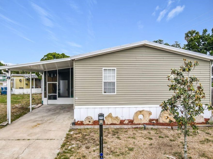 If you LOVE to FISH and BOAT, Kayak or Paddleboard, this community is perfect for you! Start enjoying the Florida lifestyle in this 2020 built Home!! NO LOT RENT, you OWN the Land. As you pull up, you notice the screen enclosed patio with a privacy shade, a lovely place to sit outside and enjoy the outdoors. With 3 bedrooms, and two bathrooms you have room for guests or a family.  Upgrades include a New Metal Roof in 2024, an additional parking slab in 2024, Smart thermostat in 2025, and new laminate flooring in two bedrooms in 2026. The large kitchen provides an eat-in space, (table and stools included) a designated pantry, and is open to the family room. The family room is spacious with lots of natural light.  The sectional sofa and large wall mounted TV with entertainment center stay with the home.  The primary bedroom can handle a king size bed with nightstands and dresser (which are included) and a walk-in closet. The ensuite bathroom has both a large garden tub to relax in or a walk-in shower if you prefer. The split bedroom plan has the two other bedrooms across the home, each spaciously similar in size.  The second bathroom comes with a tub and shower combo. Bidets are in both bathrooms. The sliding doors off the family room lead to a completely fenced area for private outdoor space or for your pets to roam. The full-sized stackable washer and dryer are indoors to make laundry easy. The monthly recreational fee provides use to a fishing pier, boat ramp, two pools, shuffleboard and bocce, a spacious clubhouse with a large kitchen, and boat slips for an additional fee.  Spot dolphins or manatees from the pier or take it to the next level with enjoying a day on the water by fishing, kayaking or boating. Just 15 minutes from New Smyrna Beach, you can also enjoy all that beach town has to offer.  Call to see this property today!