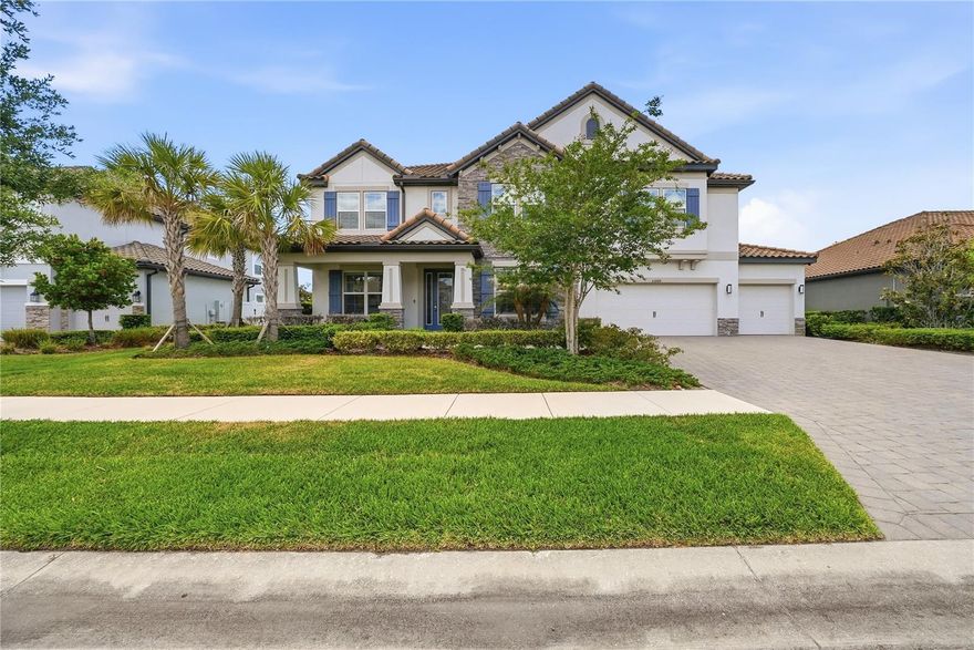 Stunning and well maintained grand residence with an abundance of luxurious features and upgrades in the gated Graybrook neighborhood of the WaterGrass community. This exquisite six-bedroom, four-bath, five-car garage pool home is a craftsman masterpiece and was built in 2022. This property boasts a generous 4,773 square feet of living space with an extremely well-designed floor plan including an office, an enormous bonus loft and multiple flex areas. The home’s stone accented exterior elevation exudes timeless sophistication, welcoming you with a grand entrance and open porch. Inside, motorized shades in the living area provide effortless control of natural light while enhancing the ambiance. The living area features gorgeous wood and porcelain accented feature wall with a built-in electric fireplace, creating a focal point that is cozy and stylish. The gourmet kitchen is a chef's delight, showcasing an oversized dual waterfall quartz island that is visually striking. The large walk-in pantry offers plenty of storage, while the dry bar with a beverage refrigerator serves as a coffee bar, and built-in GE Profile convection oven and microwave provide convenience and elegance for entertaining guests. The GE Profile electric cooktop with a range hood, white subway tile backsplash, hidden cabinets under the bar, and smart and touch-activated inlayed sink are just a few of the distinctive features this kitchen has to offer. Additionally, an extra butler's pantry provides added convenience for preparing meals and hosting events. Indulge in luxury in the primary suite, offering dual walk-in closets and a spa-like haven for a primary bedroom, complete with a water closet, a generous linen closet, a frameless glass walk-in shower, a separate deep soaking bathtub and a split dual vanity with makeup counter. Entertain in style with the large media room, with surround-sound speakers, and a high-quality projector screen for a true cinematic experience. The oversized loft at top of the stairs offers additional flexible space or relaxation zone. The property boasts ample custom trim and millwork, including crown molding, tray ceilings and feature walls, adding a level of refinement throughout the home. Upgraded LED recessed lighting, hanging light fixtures and plumbing fixtures complement the elegant design, creating a warm and welcoming atmosphere. Step into the backyard, and you'll find an oasis, providing year-round relaxation and recreation with the screened-in heated saltwater pool boasting three cascading waterfalls and two elegant fountain jets. Lounge in style on the two tanning ledges, each with removable umbrellas, or unwind in the luxurious spa after a long day. Enjoy privacy and security in the sprawling fully fenced backyard, providing a safe environment. The rare five-car garage with hanging storage and a convenient workbench is perfect for the car enthusiast or anyone in need of ample storage space. Located in the gated Graybrook neighborhood of the WaterGrass planned community offering additional amenities and community pool, as well as Watergrass Elementary School and fire department. With nearby interstate access, this growing area has the sought-after Innovation Preparatory Academy and Kirkland Ranch Academy of Innovation while close to shopping and dining of the Tampa Premium Outlets and Shops at Wiregrass.