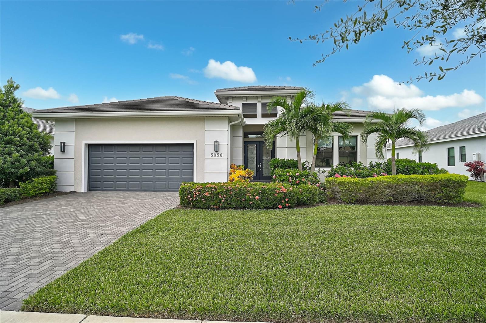 Waterfront serenity meets easy, modern living in this single-story Vilano by Kolter—2,975 sqft on a premium homesite with wide water and fountain views. A chef’s kitchen centers the open great room and dining spaces with Level 7 finishes: stacked 42" cabinetry, gas cooktop, double-waterfall granite island, premium appliances including an under-cabinet ice maker, and statement pendants. Slide the doors open and the home lives resort-style: a heated pool with sun shelf, gas fire feature, and a custom outdoor kitchen with granite, grill, sink, fridge, and generous storage. The tranquil primary retreat offers a spa bath with oversized dual-head shower and a custom walk-in closet. Thoughtful upgrades continue throughout—ideal for everyday comfort and effortless entertaining. In Cresswind at Lakewood Ranch, lawn care, irrigation, pest control, cable and high-speed internet are included, freeing time to enjoy amenities: full-time lifestyle programming, pickleball, tennis, bocce, art/ceramics/card rooms, SmartFit/EGym and yoga studio, resort-style pool & spa, and a vibrant social calendar. Request the comprehensive upgrades list; this home shows beautifully.