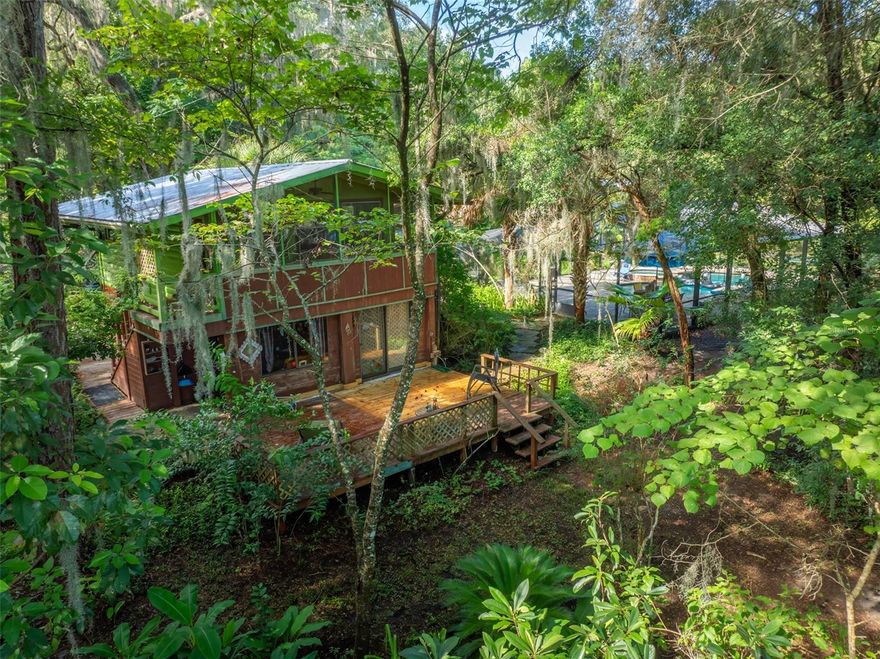 PRICE IMPROVEMENT.....Listed for under appraised value... GREAT DEAL MUST SEE!!!
Charming, serene, lakefront sanctuary on spring fed West Lake,  4.07 wooded acres. Putnam County...Low Taxes and Utilities
 Centrally located to 
St. Augustine Beach and Gainesville. Property offers a perfect blend 
of natural beauty and recreational opportunities, such as fishing, canoeing, &
 swimming.  FIVE FREESTANDING BUILDINGS with screened decks and porches accommodate 
6 or more residents or serve as art studios or business quarters. 4 full bathrooms, 1 outdoor 
shower, 2 wells, and a 16,000-gal screened-in SALTWATER POOL and HOT TUB brick paver deck. Acreage is fenced and bamboo-lined on two sides with lakefront comprising a 
third side. Maintained using organic principles by single owner for 45 years. A 1/2-acre organic vegetable garden, herb beds, and flowering plants thrive along with
over 50 mature avocado, citrus, pomegranate, loquat, banana, guava, kiwi, persimmon
and other fruit trees that dot the property. Stately Live Oaks, longleaf pines, and
flowering trees and plants lovingly tended in mulched beds or on trellises guarantee that
something is always in bloom and edible. Statuaries, birdfeeders, and
hand-crafted tilework, walkways, wooden flooring and collectables dazzle at every turn
in the buildings and along walkways. This is a magical property that has good karma. 
It is scented with ginger, orange blossom, and jasmine that attract butterflies and wildlife,
and would be ideal for community living, retirement, extended family, art studios, AirBnb 
units, recreation, or a cottage industry.