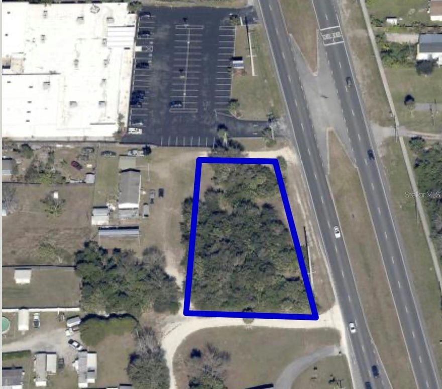 Commercial land in a prime high-traffic location along a major highway at a busy, signalized intersection.