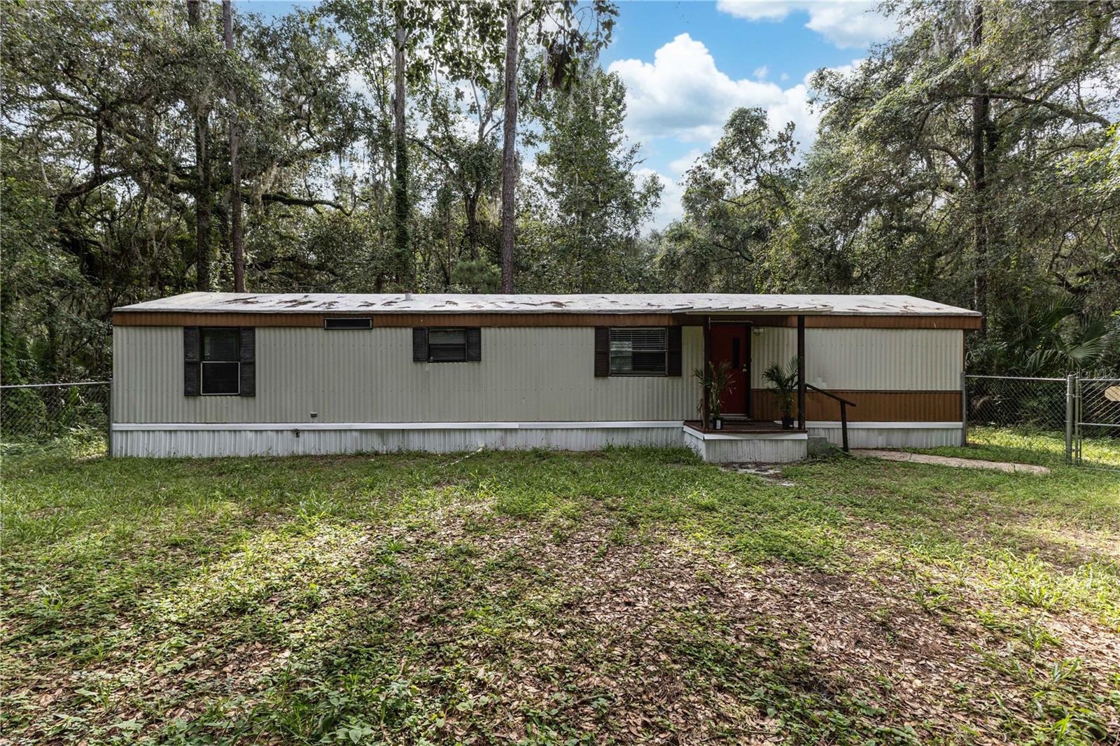 Welcome to 3080 CR 417 in beautiful Lake Panasoffkee! This charming 2-bedroom, 2-bath manufactured home has been recently refreshed with new flooring in the main living areas, fresh interior paint, updated lighting fixtures, and a recently cool-sealed roof. The inviting floor plan features a bright kitchen that opens to the living and dining space, making it ideal for comfortable everyday living.
Enjoy outdoor living with a fenced front yard, covered entry porch, and plenty of yard space. The property also includes a storage shed and convenient parking. Located just minutes from Lake Panasoffkee, I-75, and local amenities.