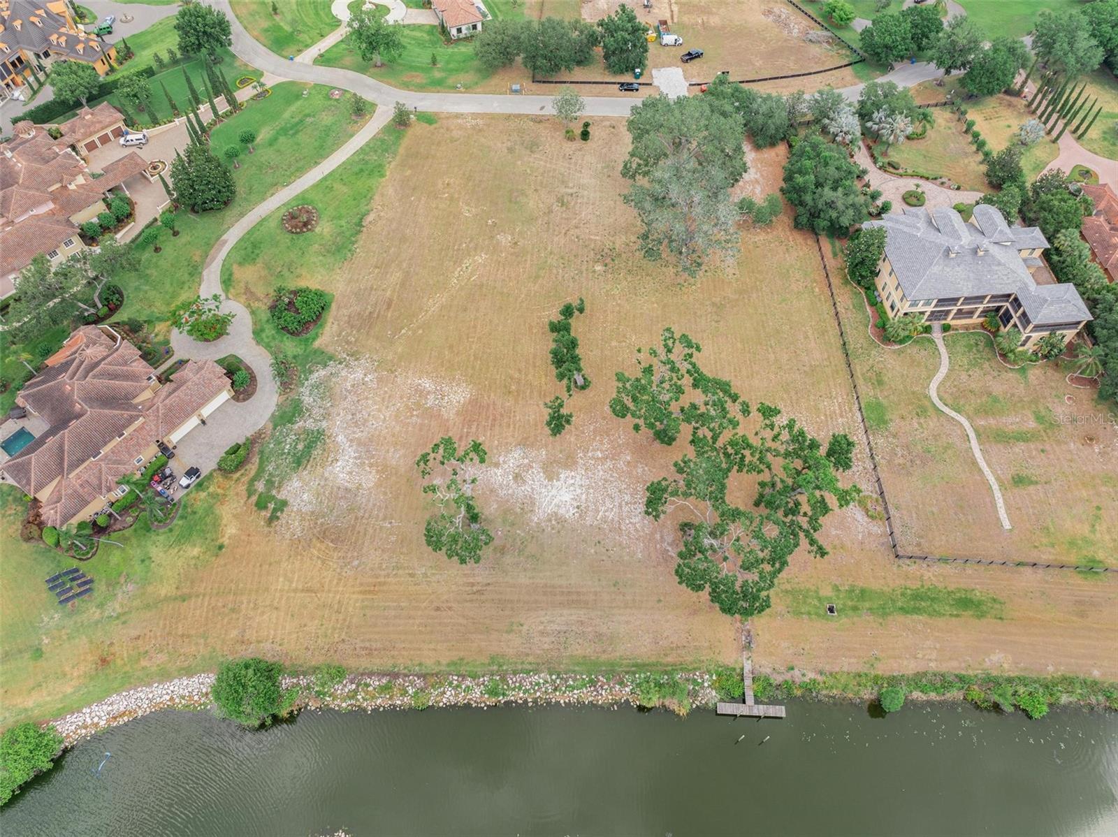Welcome to Lot 29, one of the last true waterfront estate parcels in the prestigious, guard-gated community of Stonelake Ranch. Spanning approximately 1.5 acres of high-elevation land, this premier lot offers sweeping views of Lake Thonotosassa—Hillsborough County’s largest freshwater lake—paired with the rare luxury of a private dock already in place. Perfectly suited for a custom luxury home of at least 3,500 heated square feet, this homesite is embraced by mature oak trees and elevated terrain ideal for designing a walkout basement or multi-level estate. Enjoy direct access to skiable waters for boating, jet skiing, paddleboarding, and more—all from your backyard. The northeast-facing orientation offers stunning sunrises and tranquil lakeside evenings, making this lot a true Florida dream. Residents of Stonelake Ranch enjoy access to world-class amenities, including a lakeside clubhouse, fitness center, private boat launch, equestrian trails, and a 37-acre private lake. Located just minutes from I-75 and I-4, with easy access to Tampa, Orlando, and the Gulf Coast, this is your chance to create a custom lakefront retreat in one of Central Florida’s most exclusive communities.